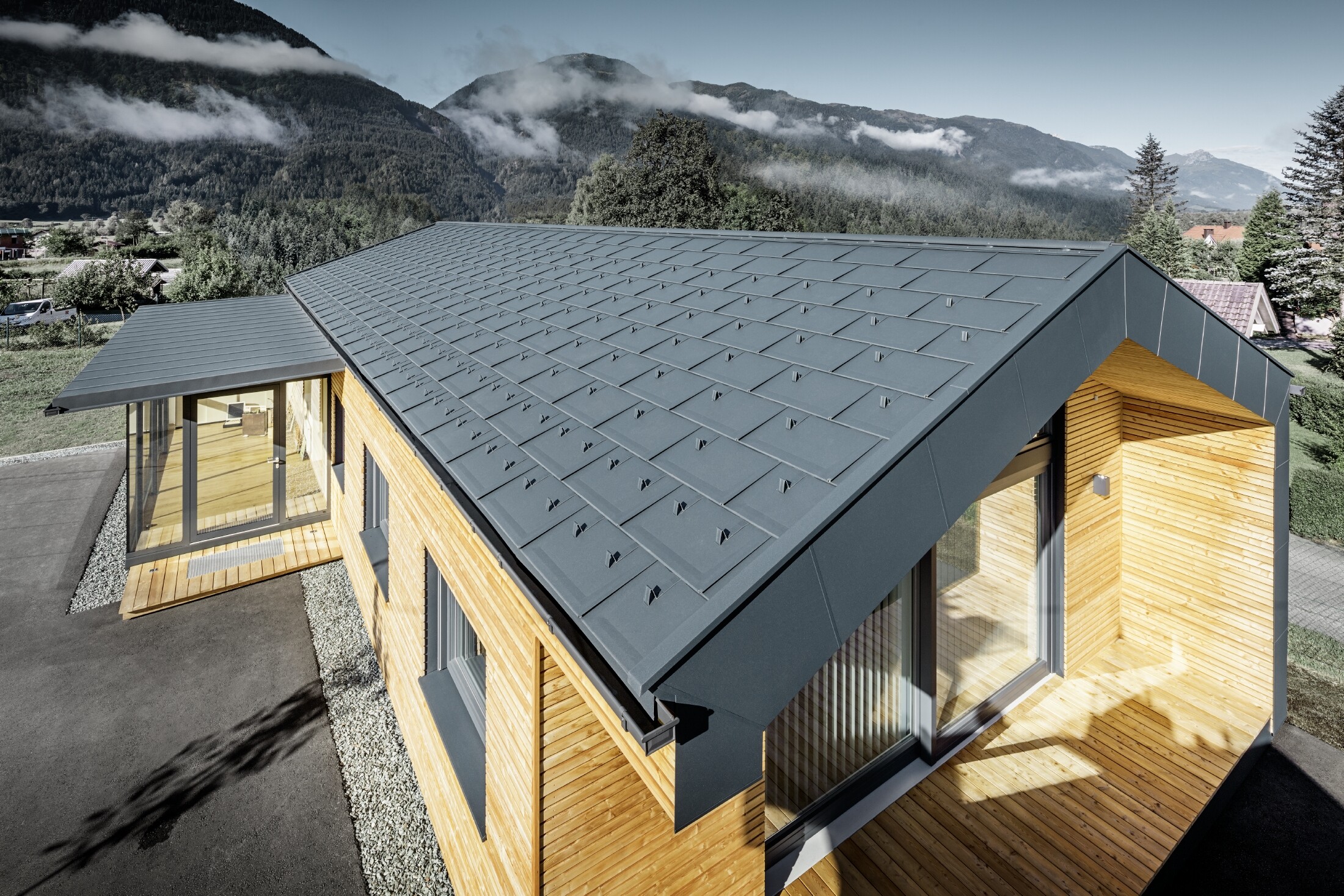 Nouvel immeuble de bureaux de Holzbau Faltheiner avec une façade en bois de mélèze, des fenêtres généreuses et une toiture PREFA en anthracite.