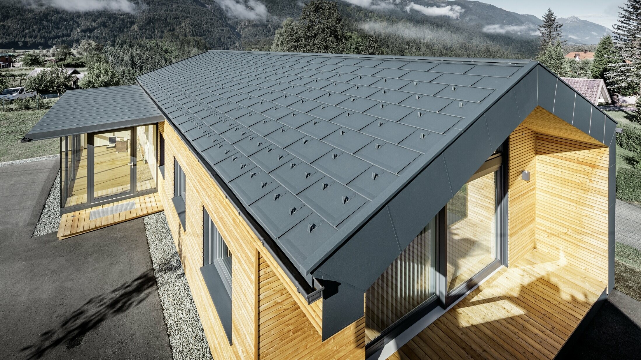 Nouvel immeuble de bureaux de Holzbau Faltheiner avec une façade en bois de mélèze, des fenêtres généreuses et une toiture PREFA en anthracite.