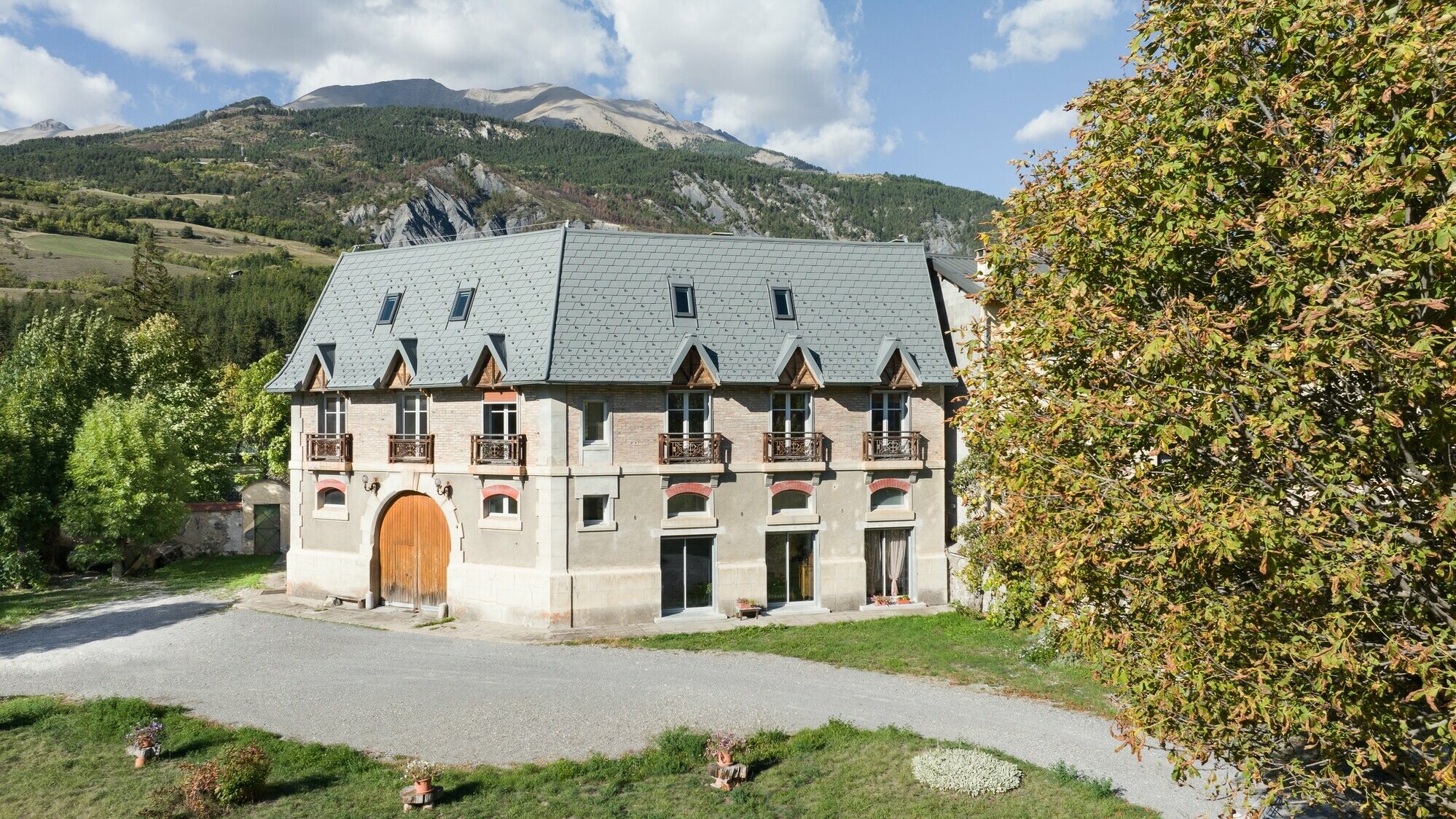 Vue éloignée de cette ferme dont la nouvelle toiture a été rénovée en bardeau PREFA dans la teinte P.10 gris souris stucco