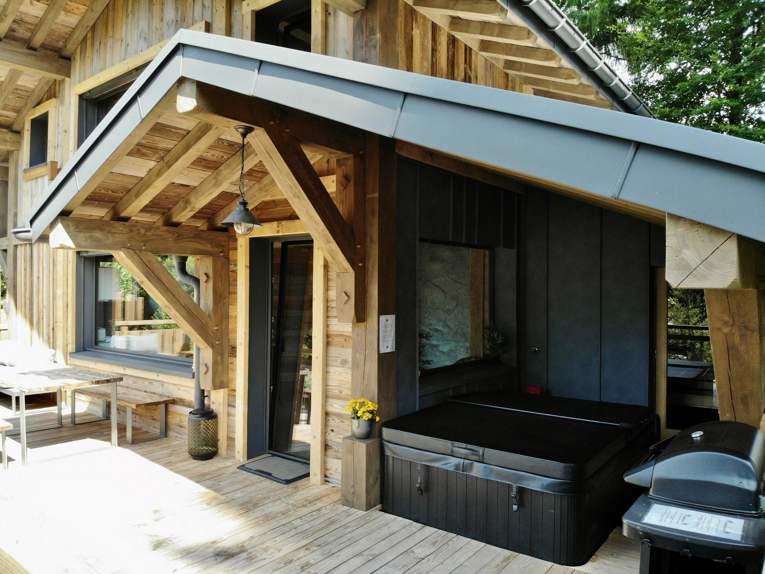 Photo depuis la terrasse du gîte vosgiens, on voit le jacuzzi en fond avec le mur en Prefalz stucco