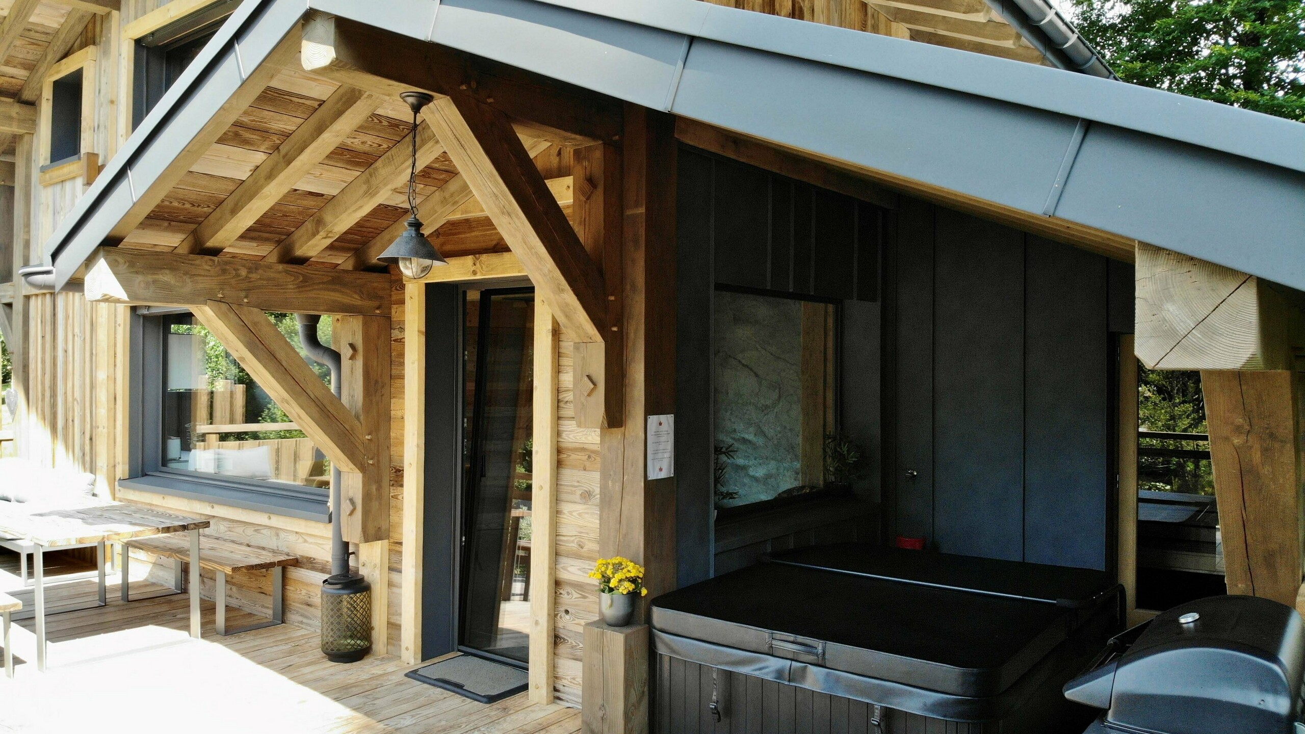 Photo depuis la terrasse du gîte vosgiens, on voit le jacuzzi en fond avec le mur en Prefalz stucco