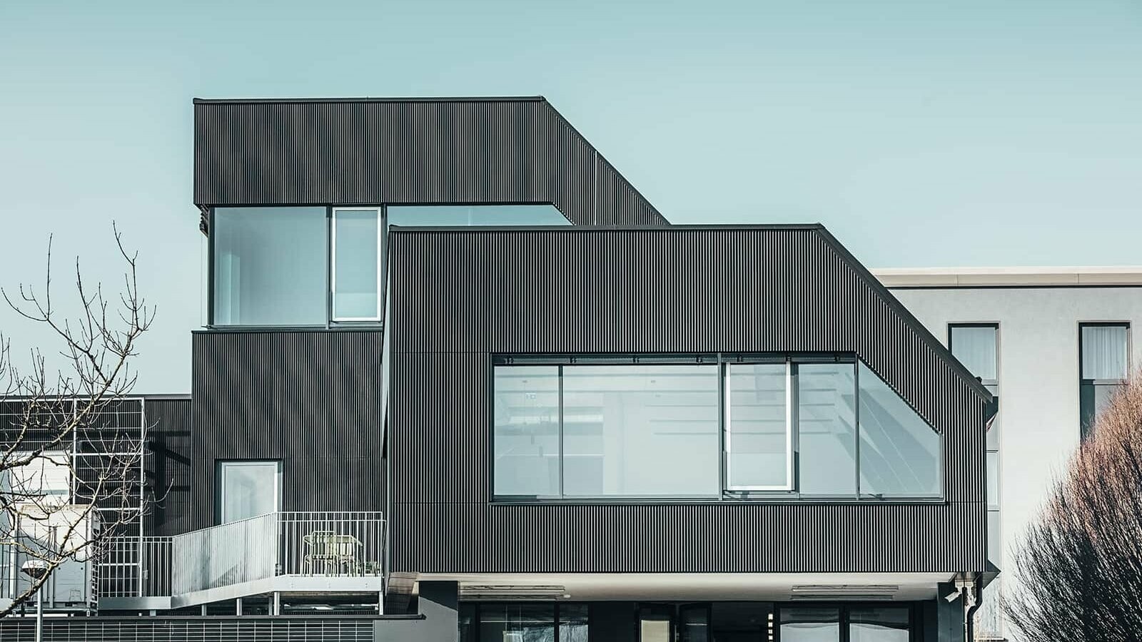 Vue latérale du bâtiment du café Amann par une journée ensoleillée. Un profil ondulé noir a été utilisé pour protéger le bâtiment.