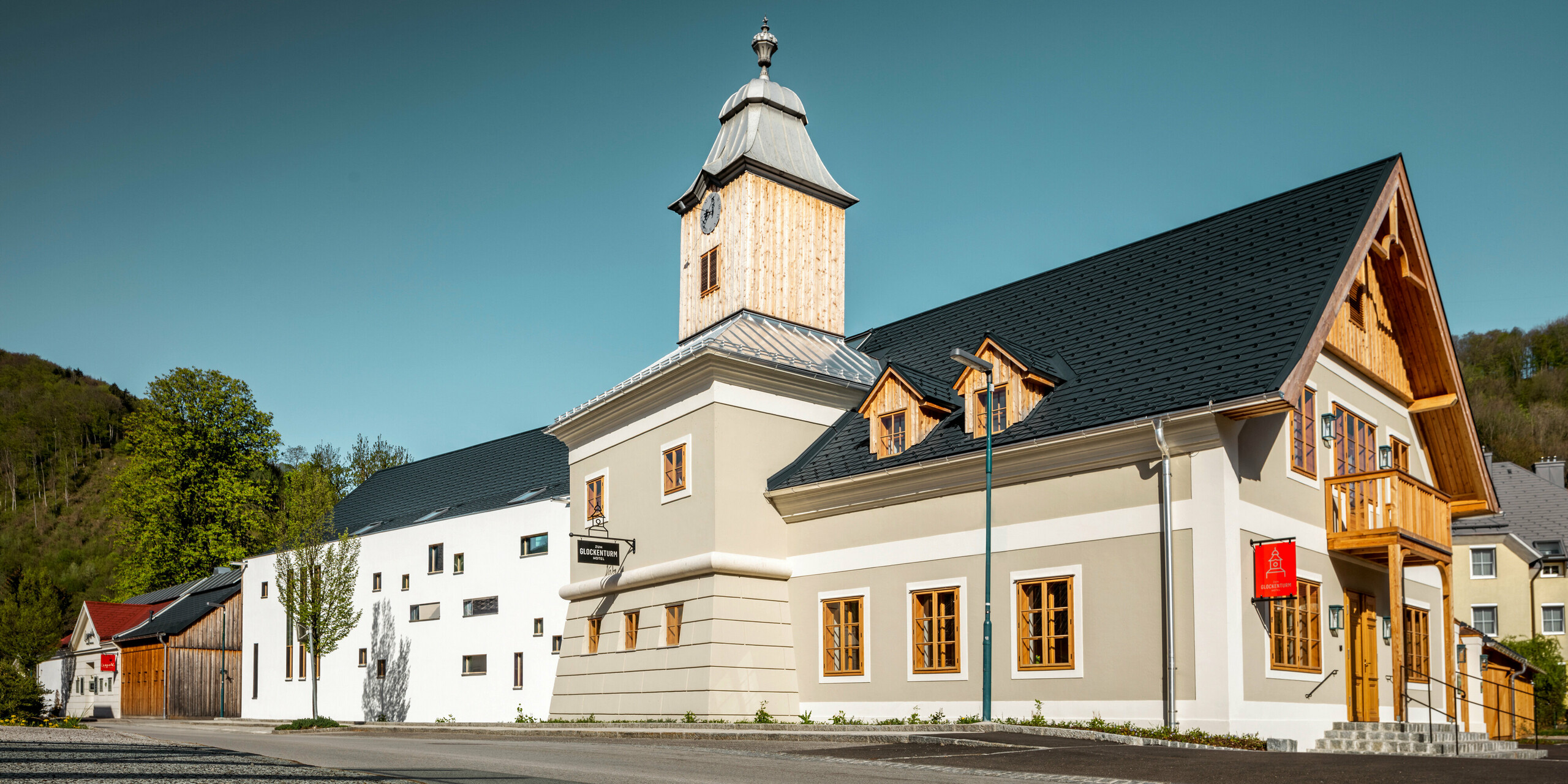 Le toit de l'hôtel Glockenturm à Marktl près de Lilienfeld a été recouvert de bardeaux PREFA en anthracite P.10. Le système de drainage du toit PREFA du bâtiment reste naturel. Non loin de l'hôtel Glockenturm se trouve le Leopold - notre auberge. Le bâtiment du restaurant a également été recouvert de produits PREFA.