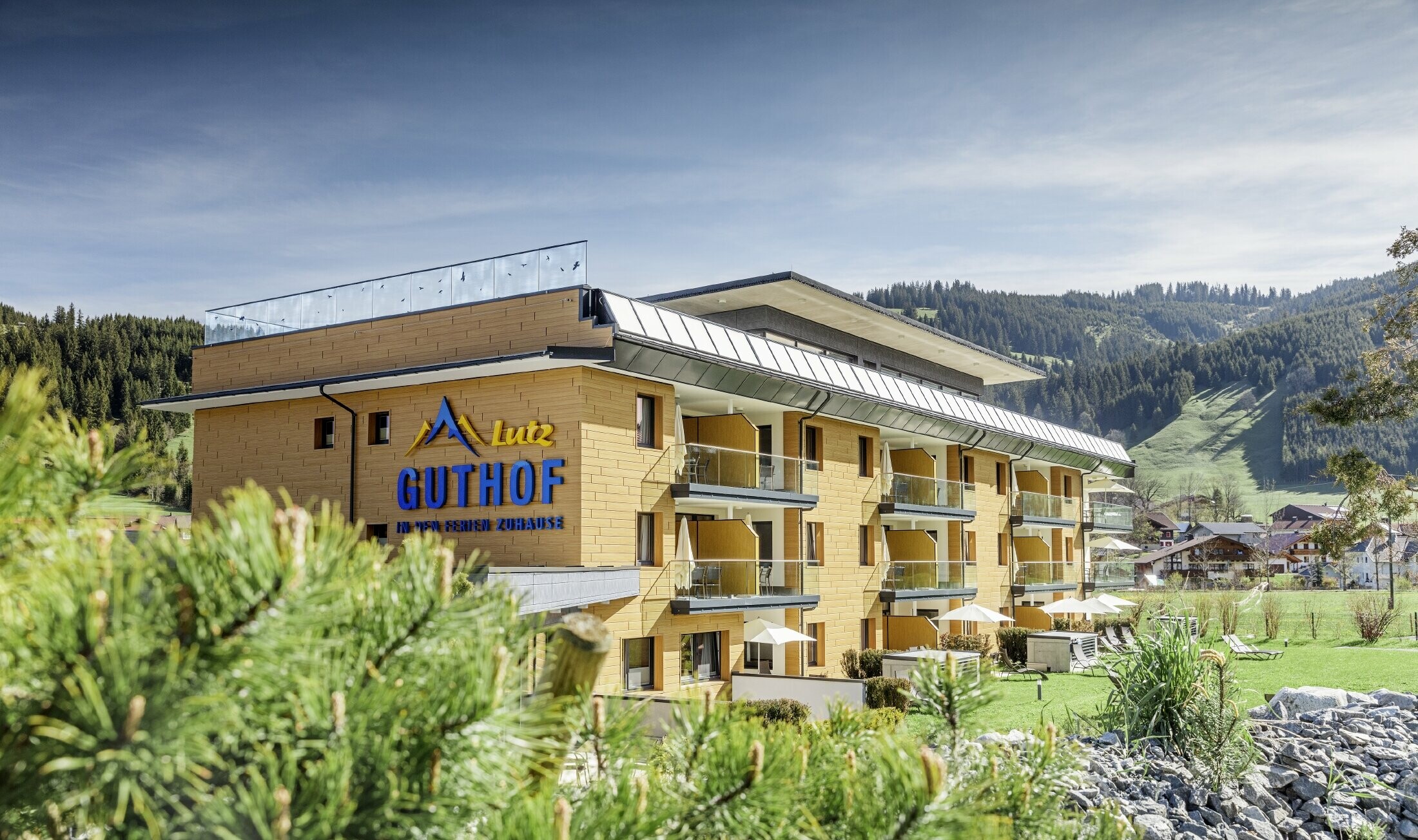 Entouré par la nature, l’établissement Guthof Lutz a été habillé avec les Sidings PREFA couleur chêne naturel. Le logo des appartements de vacances est également visible sur la façade.