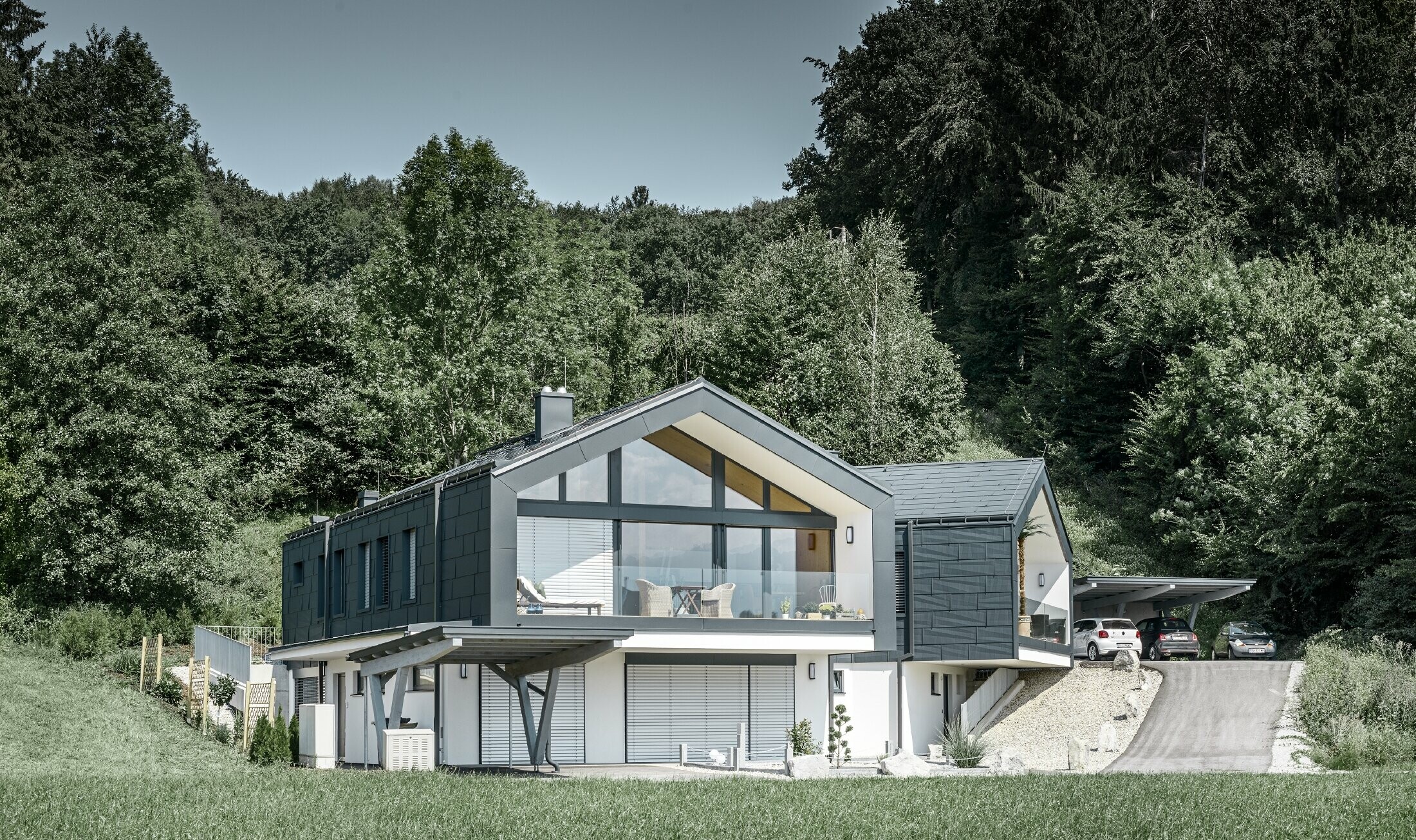 Maison en copropriété avec large façade vitrée — Toiture et façade réalisées avec des panneaux FX.12 PREFA couleur anthracite