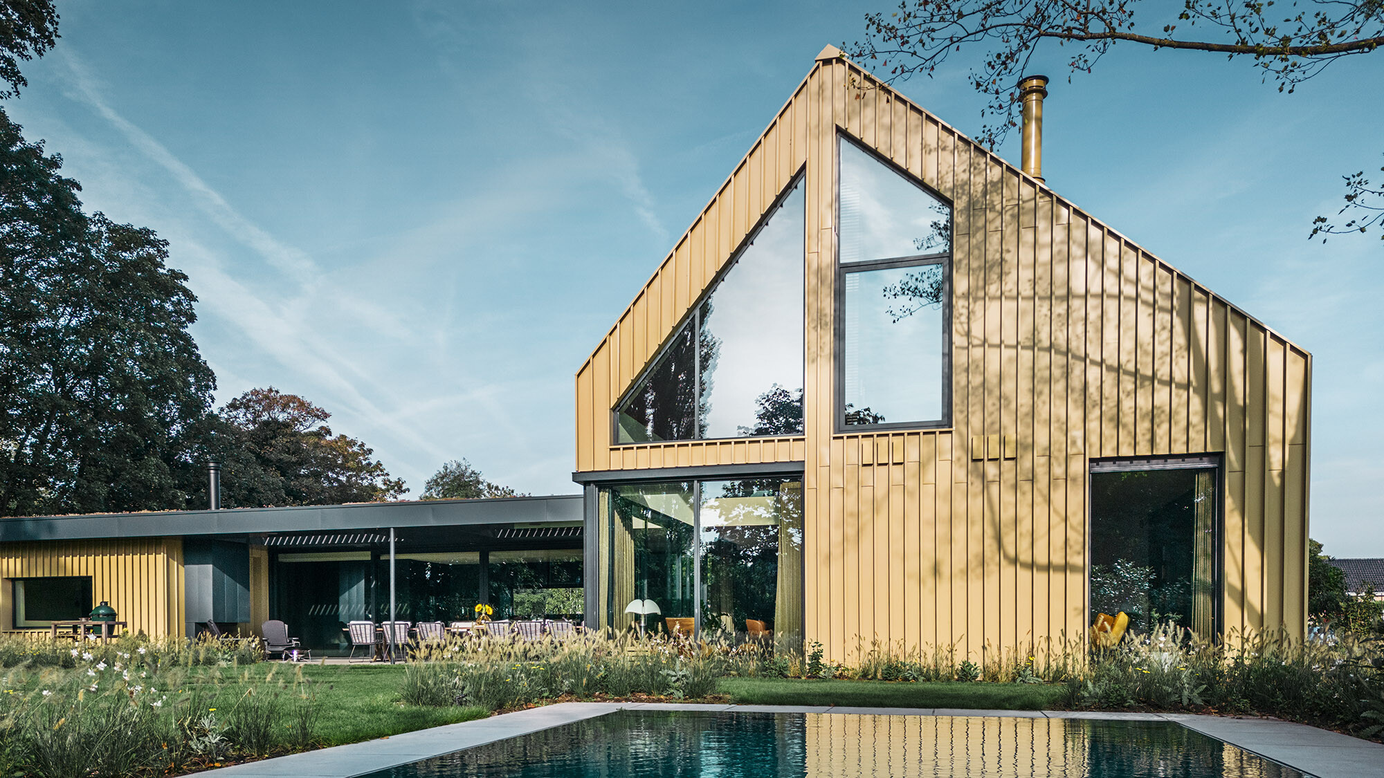 L'arrière de la maison avec vue sur la généreuse façade vitrée et la piscine.