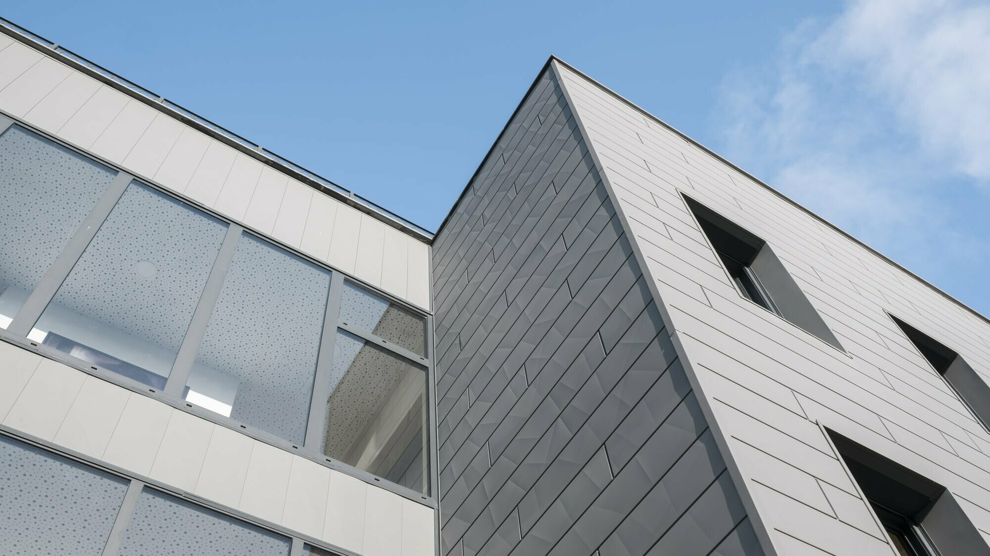 Vue du bas de l'immeuble résidentiel L'Iris dont la façade est habillée de Siding.X en aluminium PREFA