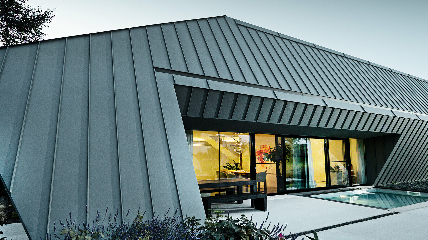 Maison individuelle neuve avec toit et façade PREFA en aluminium de couleurs P.10 anthracite et P.10 gris souris.