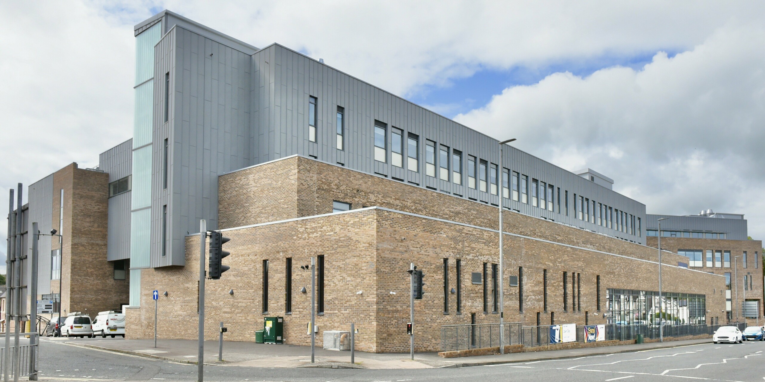 Vue de la zone d'entrée du North Regional College à Coleraine. La façade en aluminium PREFALZ en gris quartz offre un contraste moderne avec l'architecture historique en briques et offre une durabilité durable et une élégance de design grâce au revêtement à joint debout.