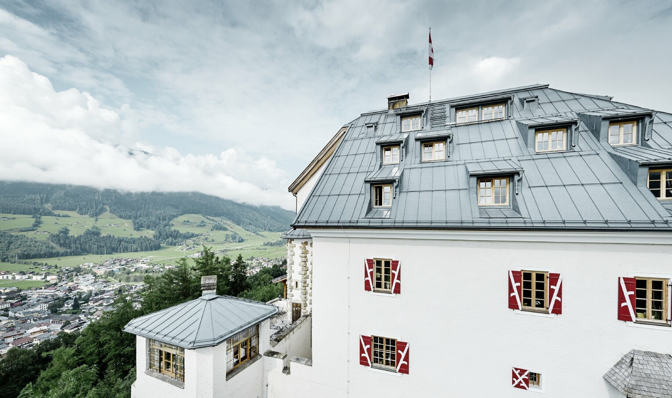 Château de Mittersill entouré d’arbres et de montagnes — Toiture rénovée avec des bandes Prefalz de couleur gris pierre