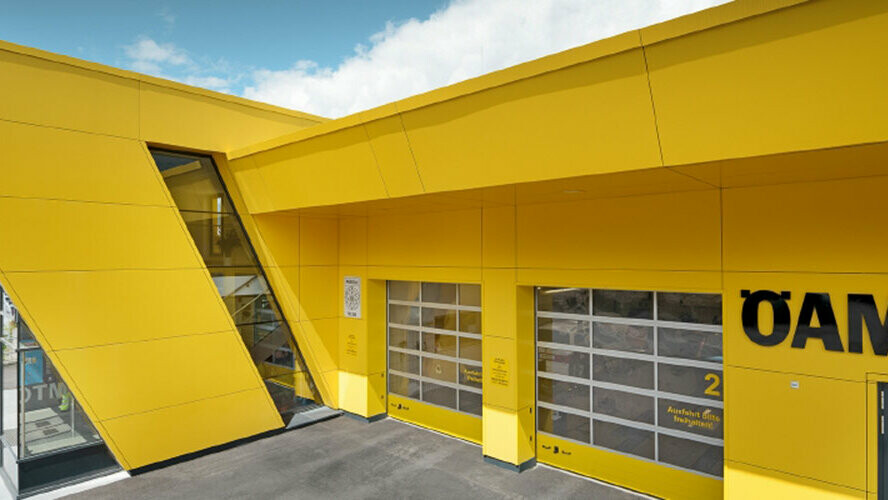 Base de l’ÖAMTC avec panneaux composites PREFA couleur jaune colza, installés comme façade suspendue et ventilée.