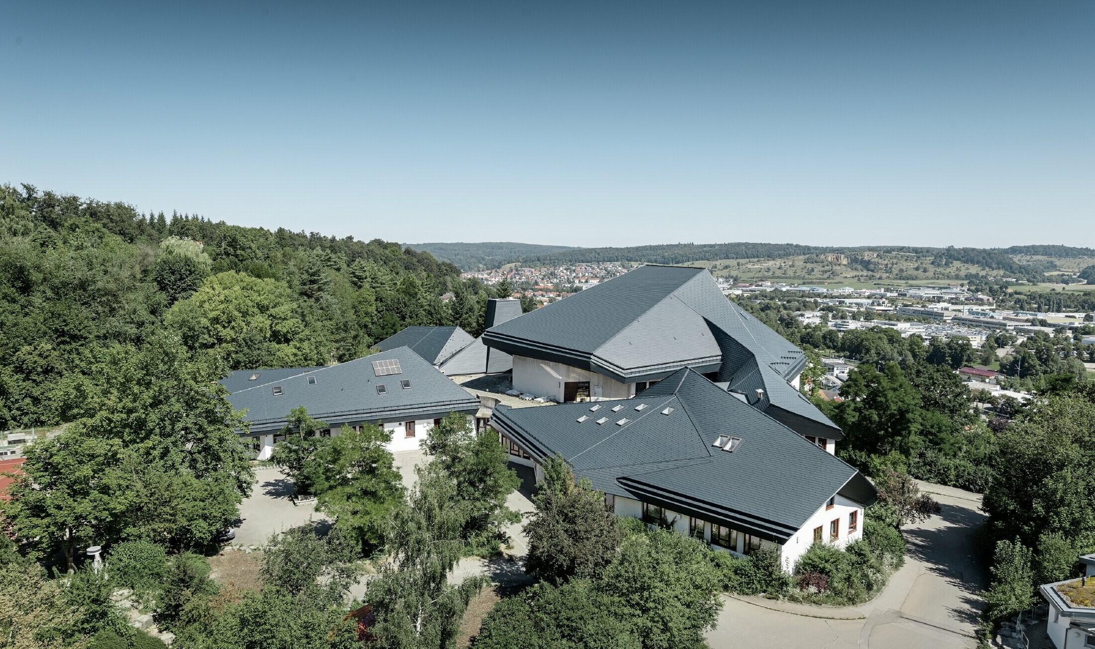 École Waldorf de Heidenheim au toit rénové — L’importante toiture aux nombreux angles, recoins et inclinaisons a été réalisée avec des bardeaux PREFA anthracite