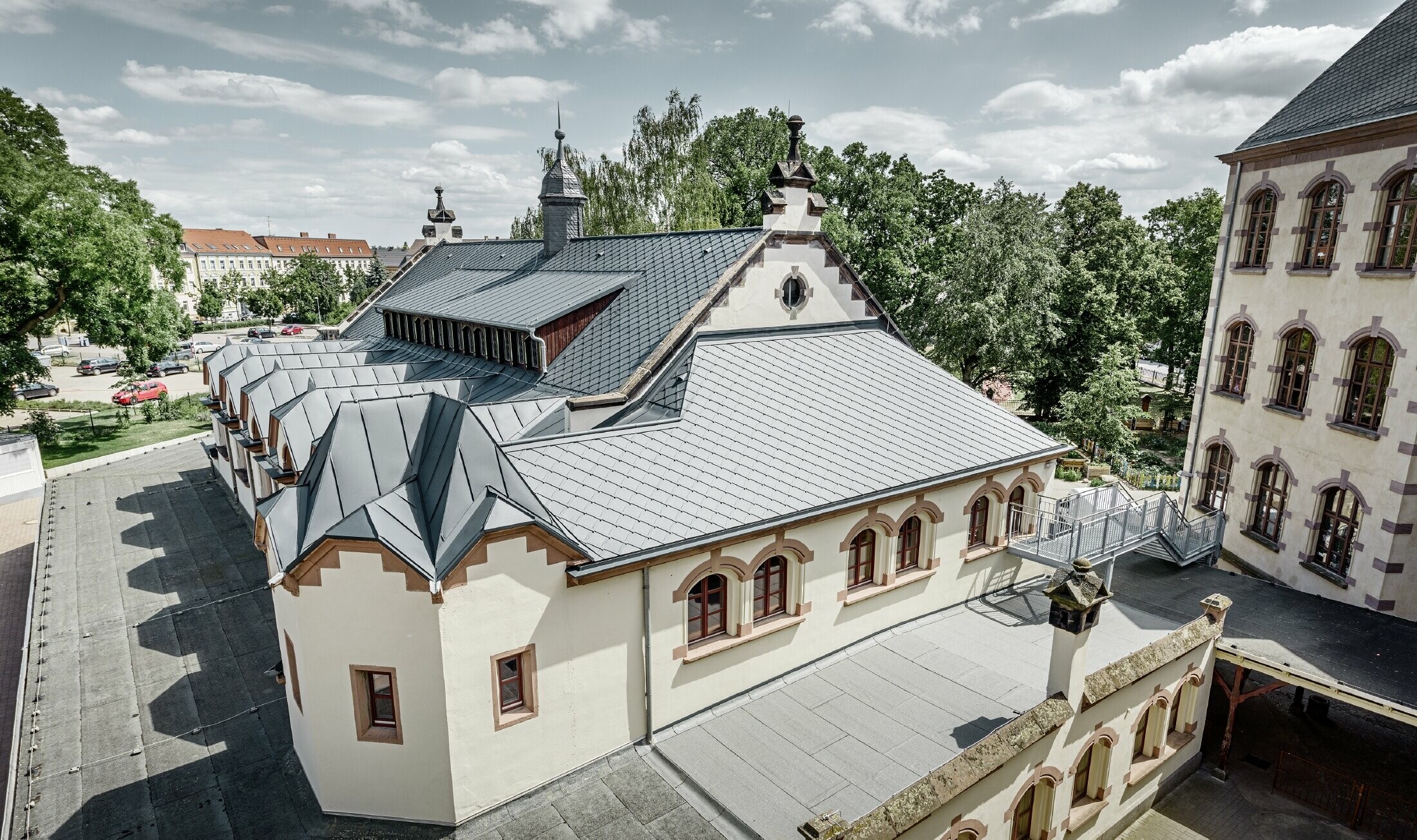 Salle de sport fraîchement rénovée de l’école de Lutherstadt Wittenberg — Toiture en aluminium PREFA réalisée avec des losanges de toiture et bandes Prefalz de couleur anthracite