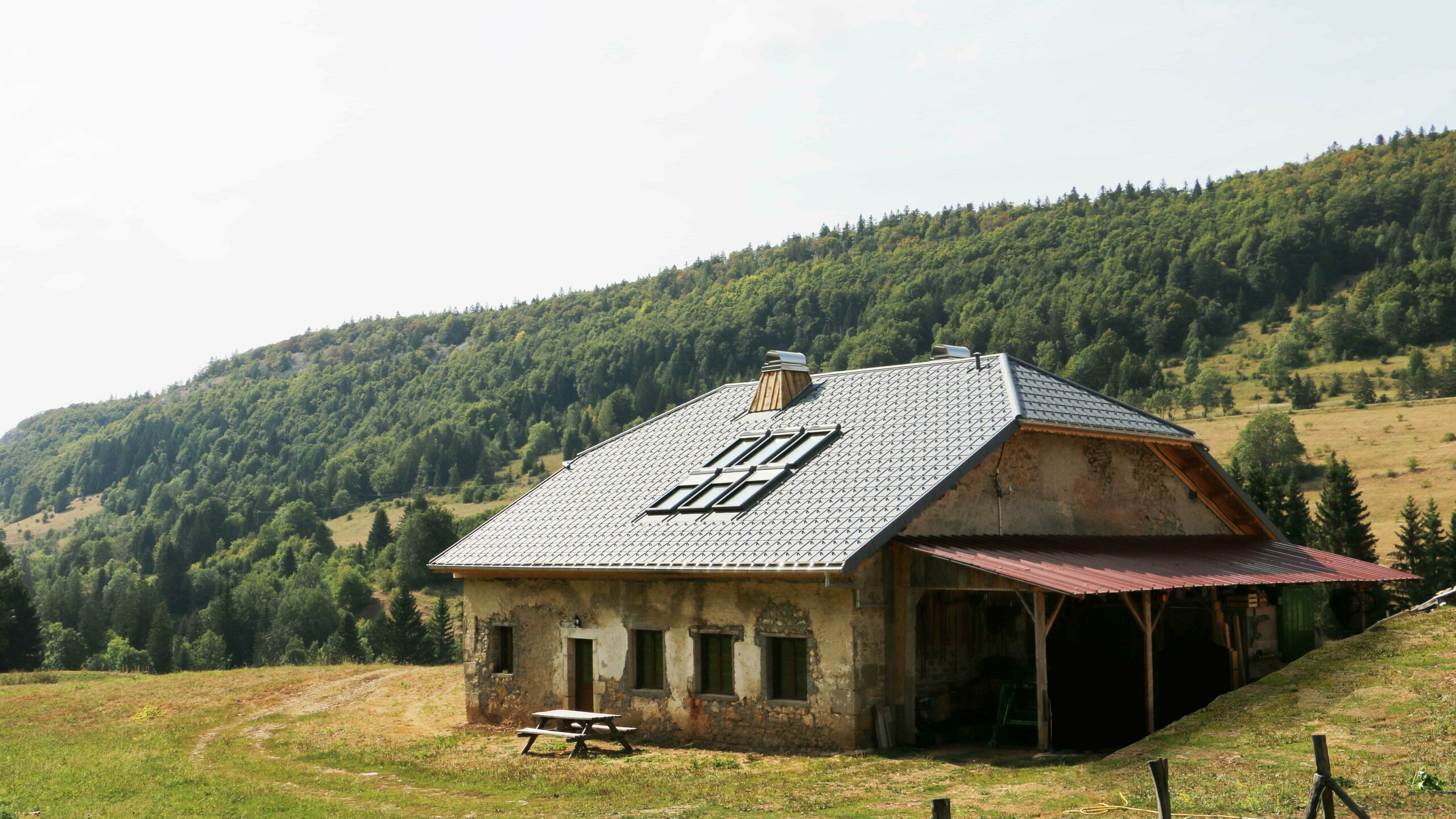 Vue éloignée de ce chalet dont la couverture a été rénovée avec les tuiles en aluminium prefa choisies dans la teinte P.10 gris pierre