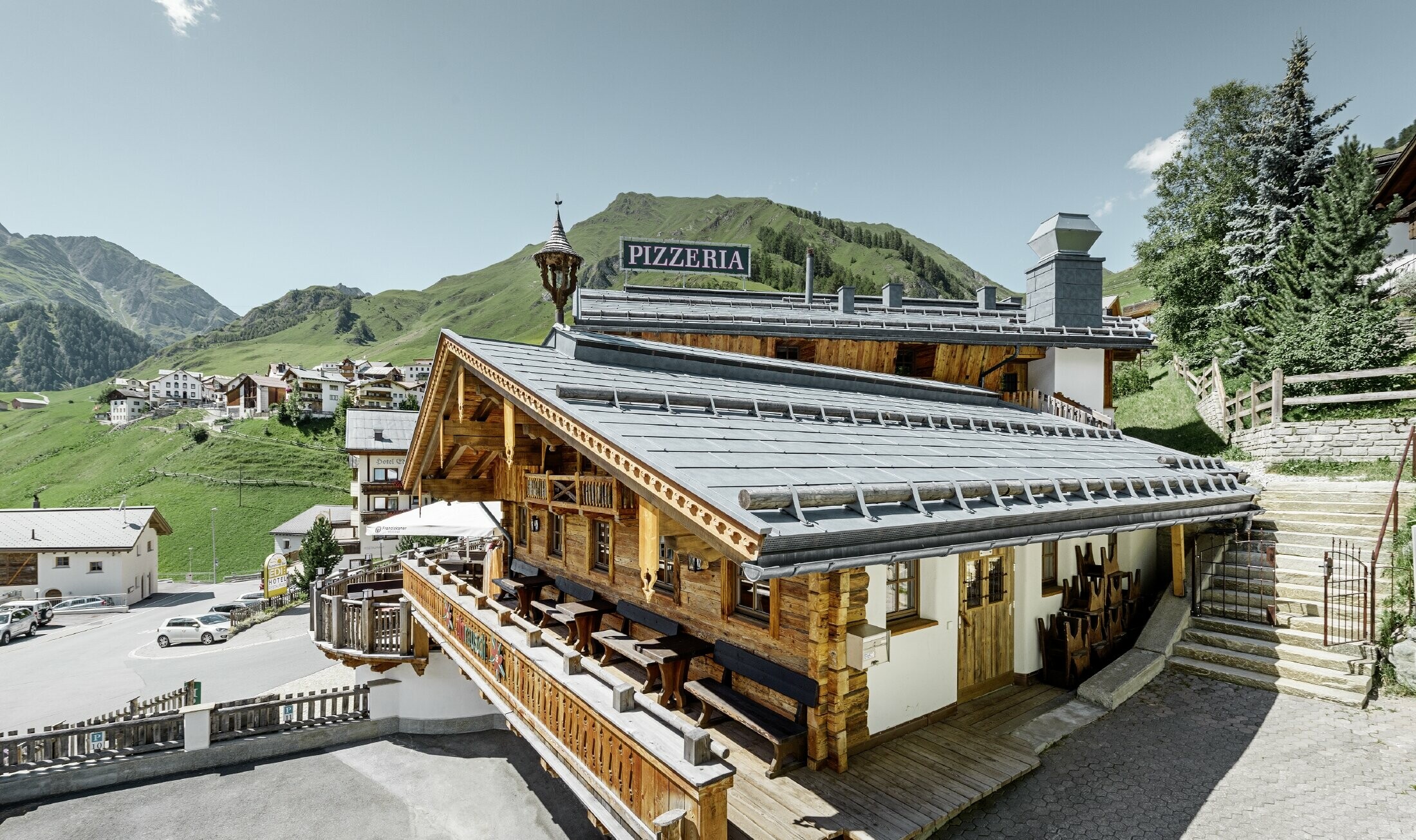 Restaurant Almrausch au cœur d’un décor de montagnes — Toiture PREFA réalisée avec des panneaux de toiture FX.12 gris pierre et dotée de tubes pare-neige