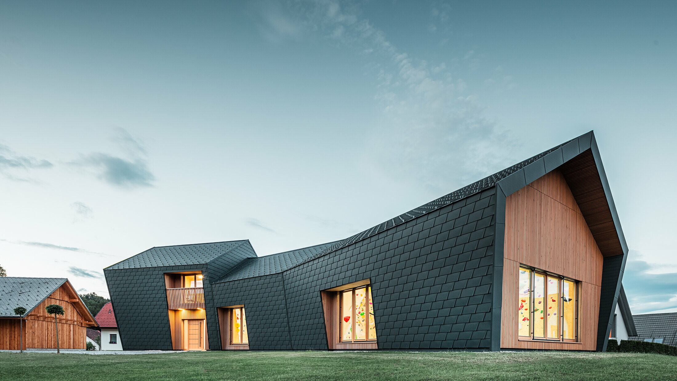 Salle avec façade PREFA sombre et éléments en bois