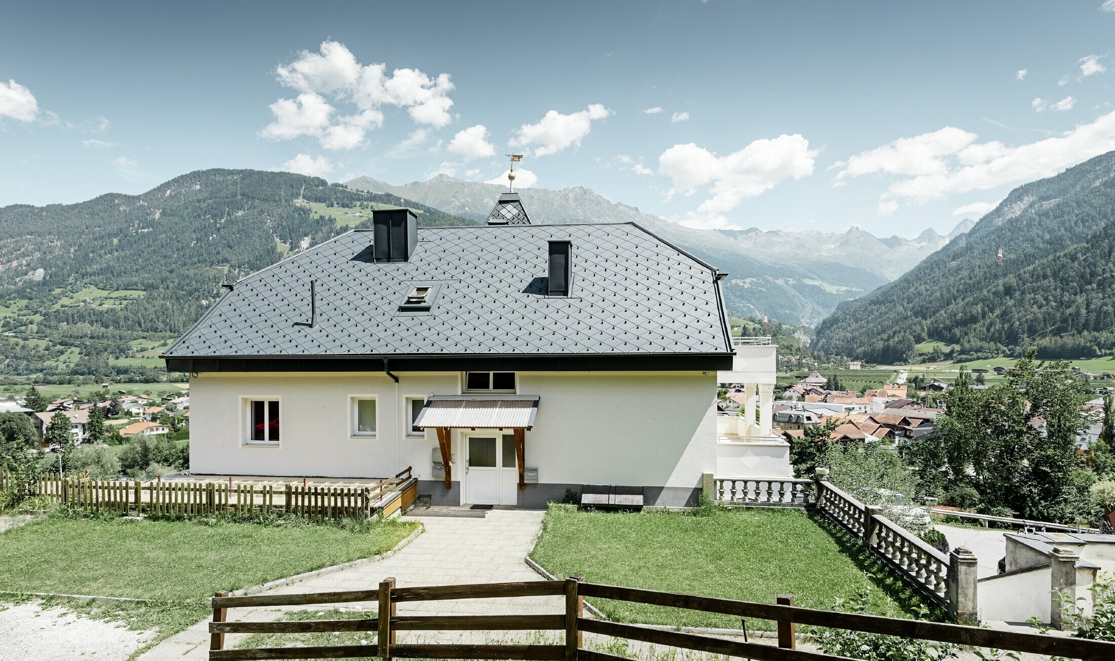 Villa flanquée d’une tour et hébergeant une pizzéria au rez-de-chaussée — Toiture en aluminium PREFA de couleur anthracite