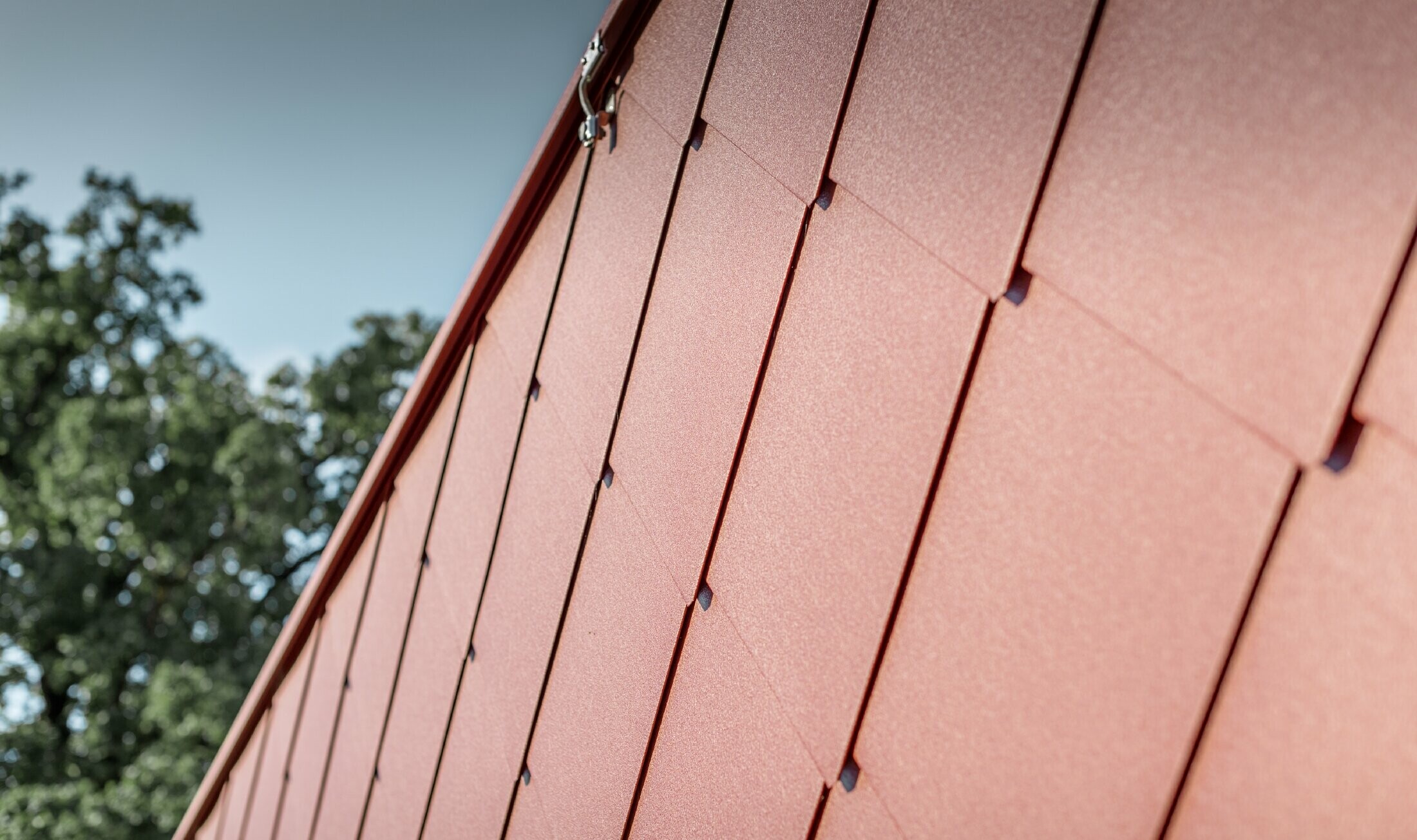 Vue détaillée du losange de façade 44 × 44 couleur rouge oxyde de PREFA, posé sur le Kerzenwelt de Schlägl ;