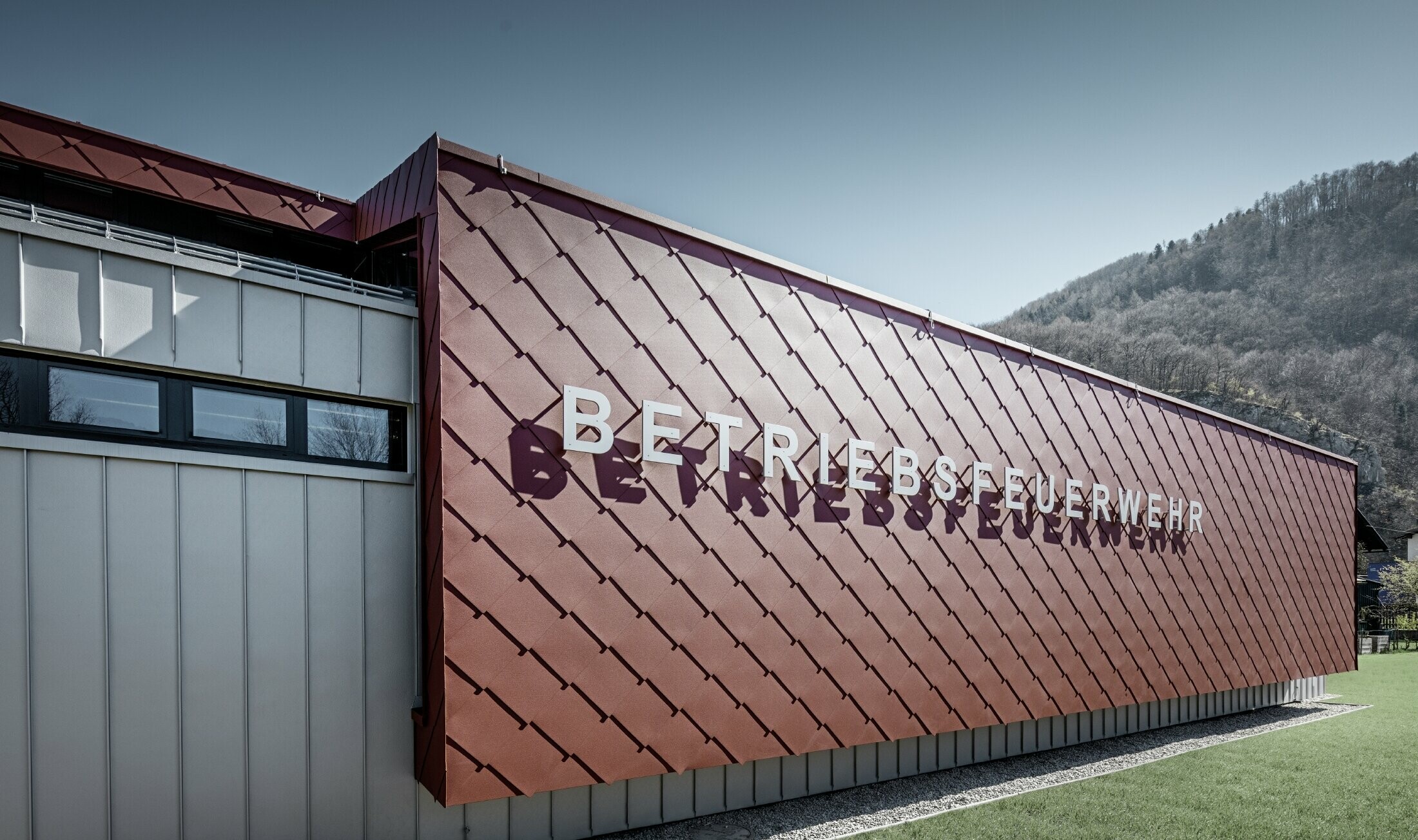 La façade de la caserne de sapeurs pompiers de l’entreprise à Marktl/Lilienfeld a été habillée avec le losange de façade 44 x 44 couleur rouge oxyde, l’inscription « Betriebsfeuerwehr » a été apposée.