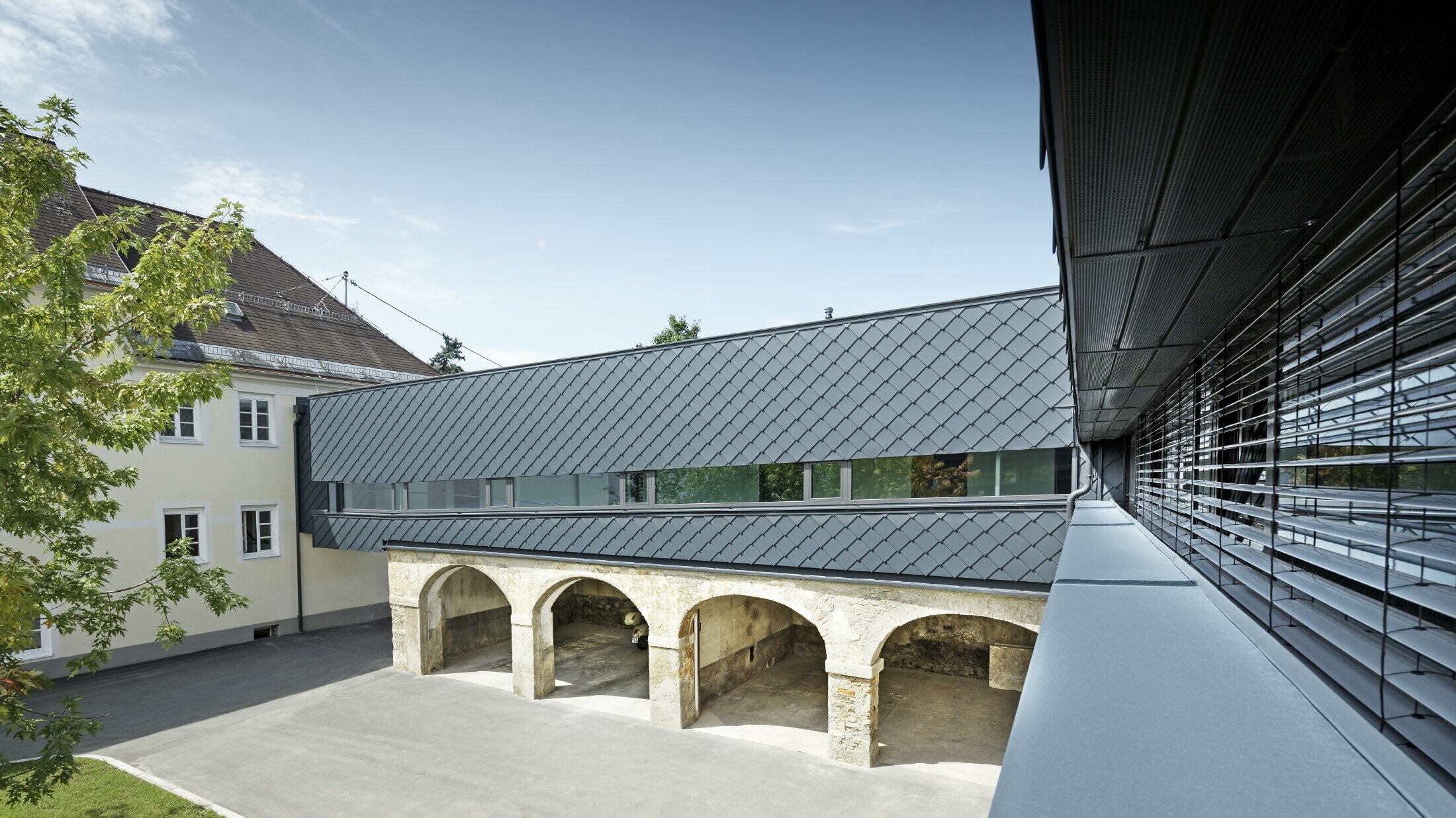 L’étage de ce bâtiment classé est revêtu avec le losange de façade PREFA 29 x 29 en anthracite : les anciennes structures du rez-de-chaussée s’harmonisent ainsi parfaitement avec les nouveaux losanges.