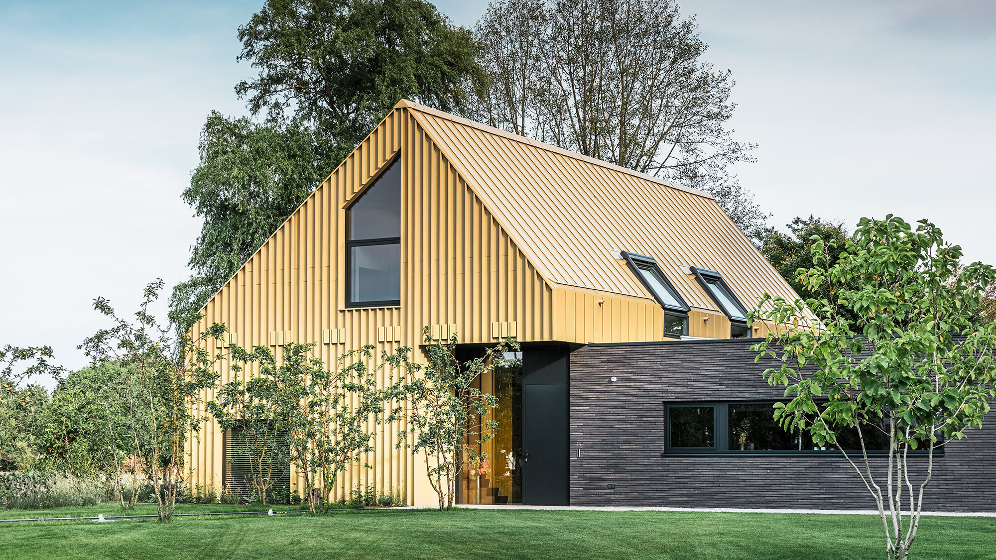 La maison vue de côté en perspective normale : un bâtiment bas allongé s'insère latéralement dans la maison principale.