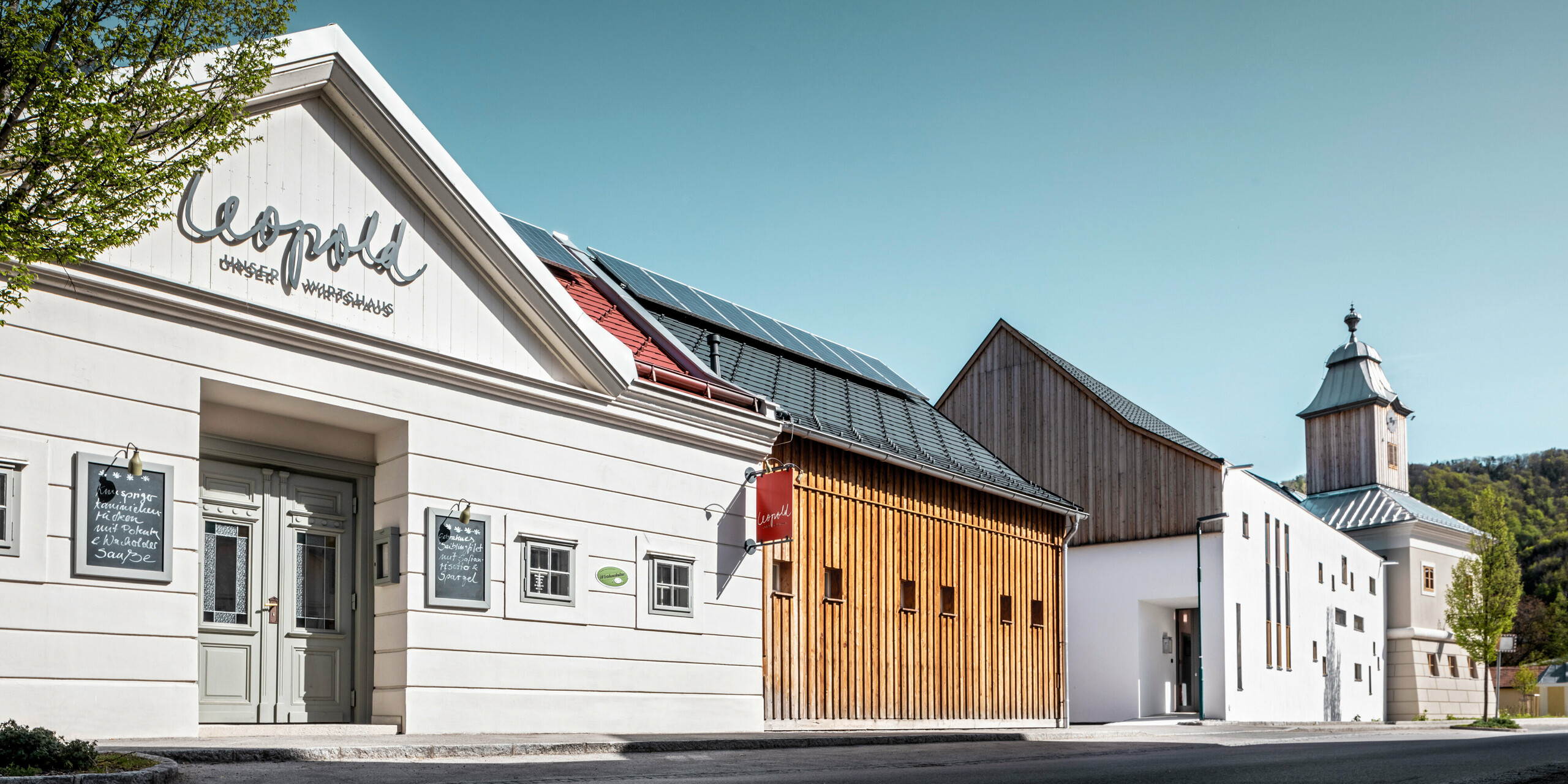 Le toit de l'hôtel Glockenturm à Marktl près de Lilienfeld a été recouvert de bardeaux PREFA en anthracite P.10. Le système de drainage du toit PREFA du bâtiment reste naturel. Non loin de l'hôtel Glockenturm se trouve le Leopold - notre auberge. Le bâtiment du restaurant a également été recouvert de produits PREFA.