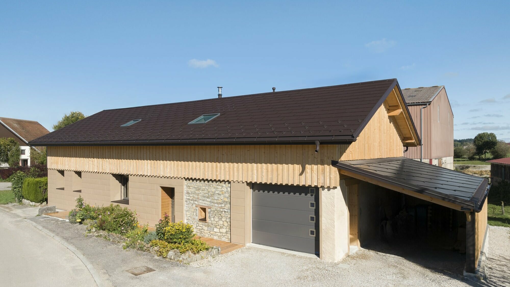 Photo d'ensemble de cette maison individuelle récemment rénovée à l'aide de plusieurs produit PREFA : le R.16 pour la couverture et le Siding.X pour la façade