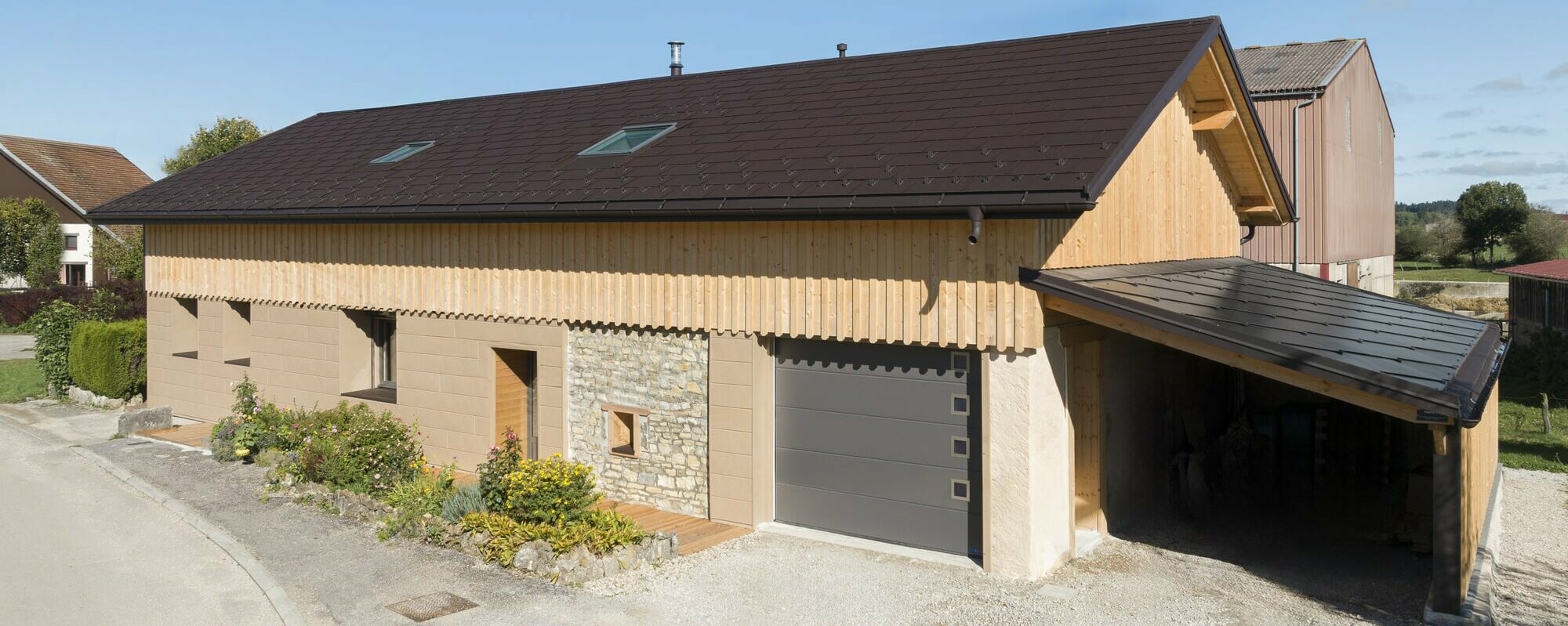 Photo d'ensemble de cette maison individuelle récemment rénovée à l'aide de plusieurs produit PREFA : le R.16 pour la couverture et le Siding.X pour la façade