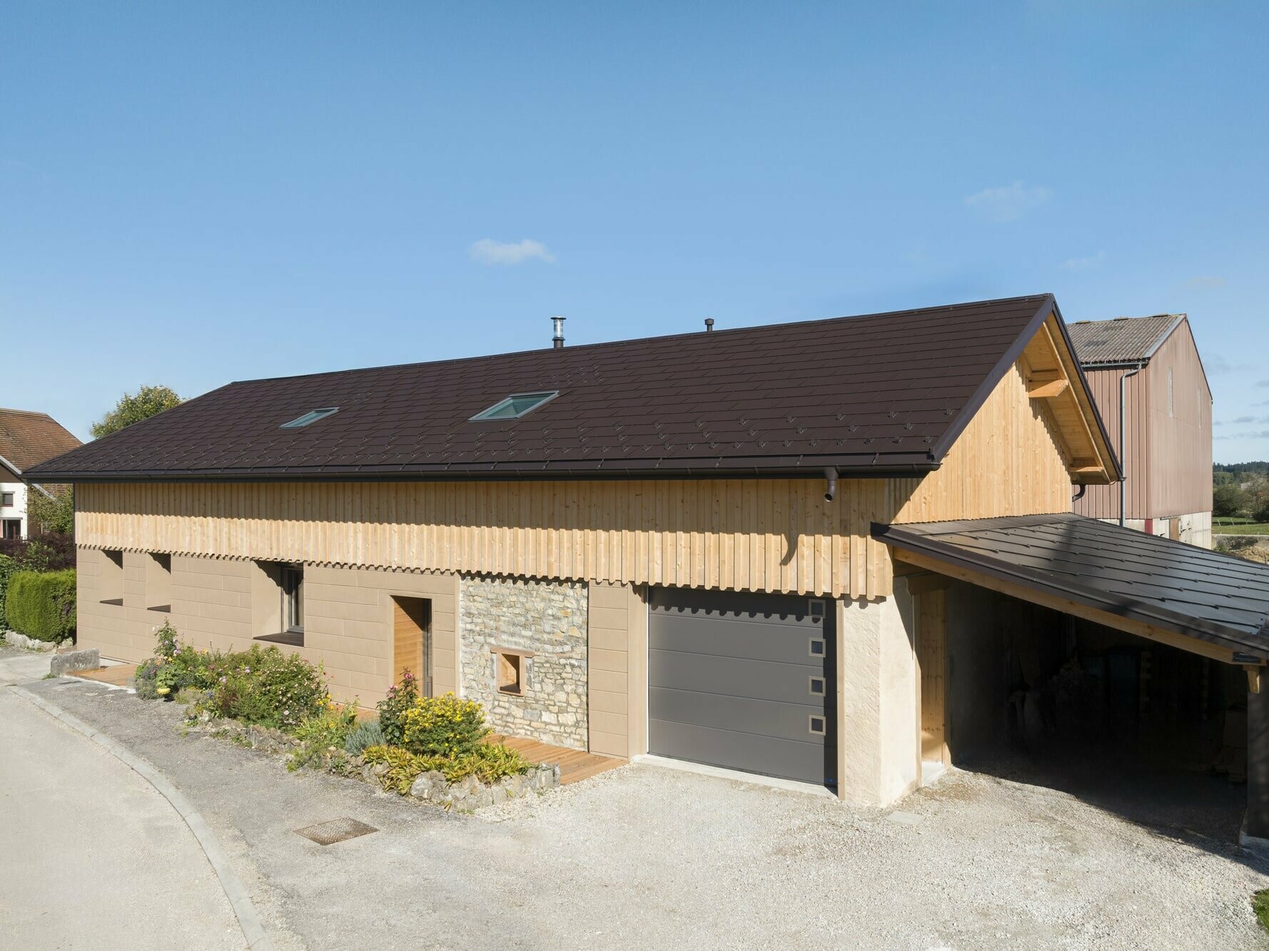 Photo d'ensemble de cette maison individuelle récemment rénovée à l'aide de plusieurs produit PREFA : le R.16 pour la couverture et le Siding.X pour la façade