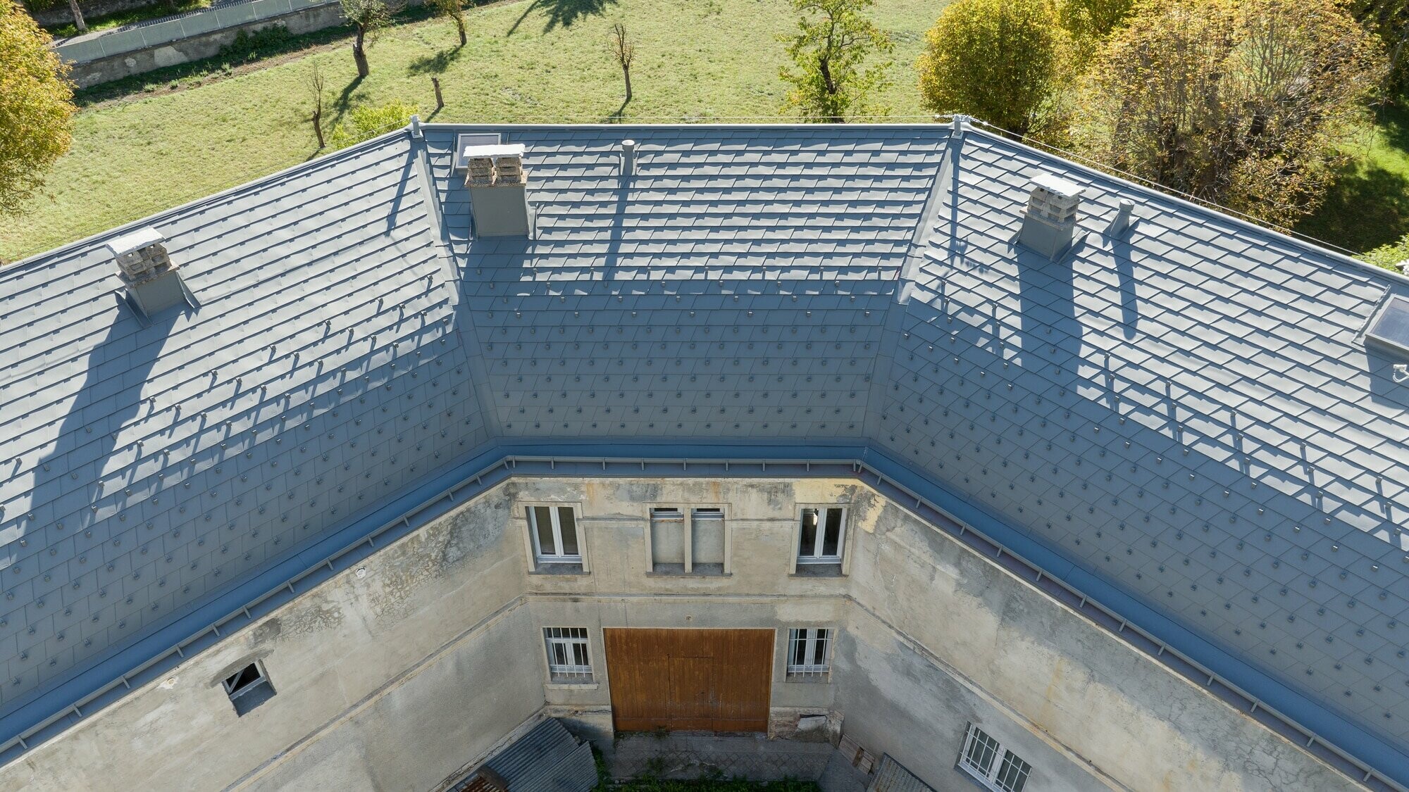 Vue du ciel de la nouvelle toiture en bardeau PREFA dans la teinte P.10 gris souris stucco