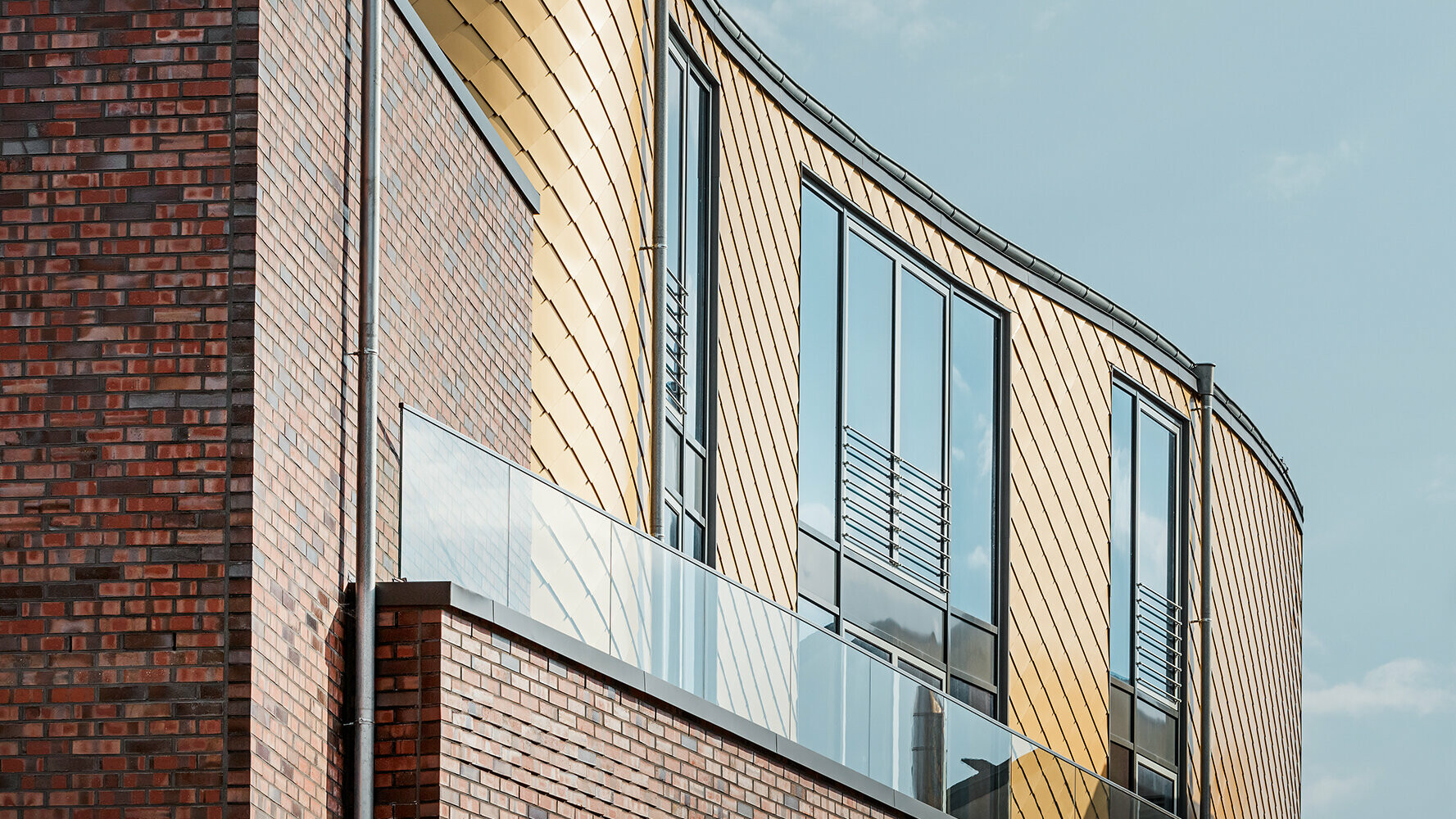 Revêtement de façade avec losanges PREFA dorés associé à une façade en briques