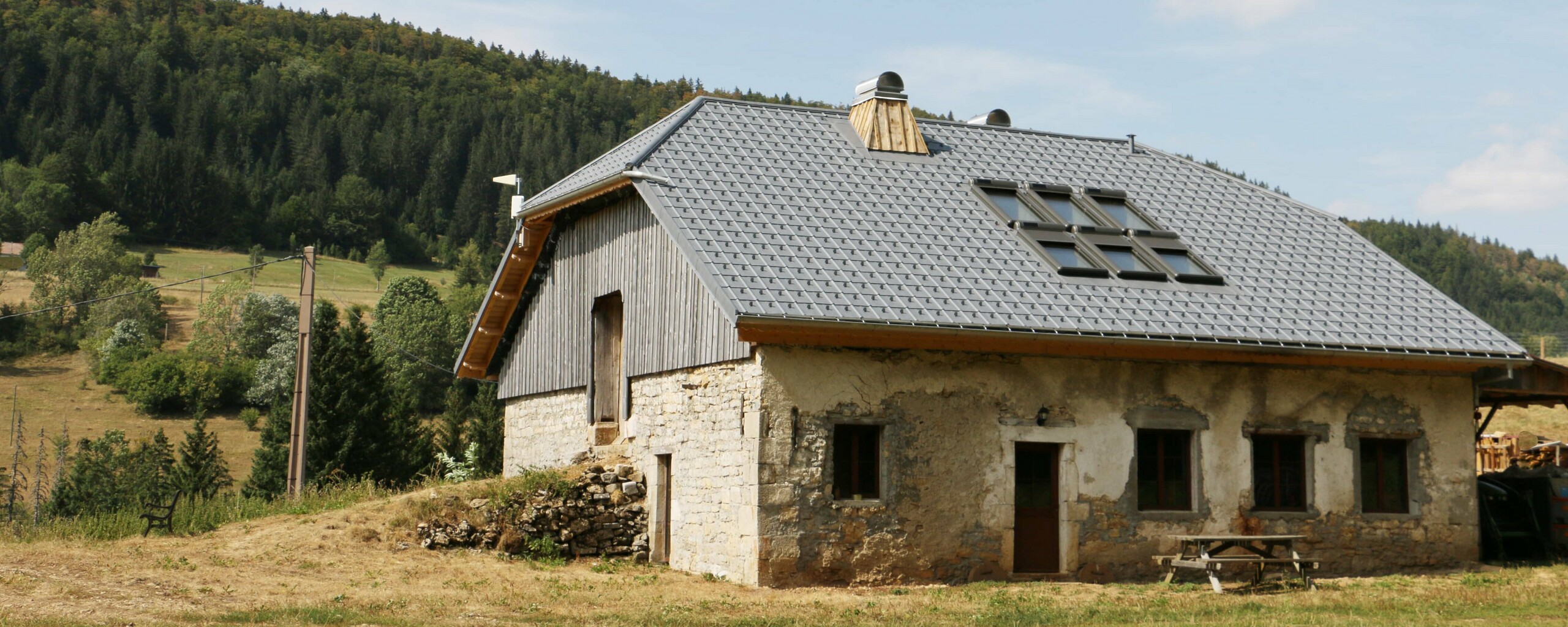 Vue d'ensemble de ce chalet dont la couverture a été rénovée avec les tuiles en aluminium prefa choisies dans la teinte P.10 gris pierre