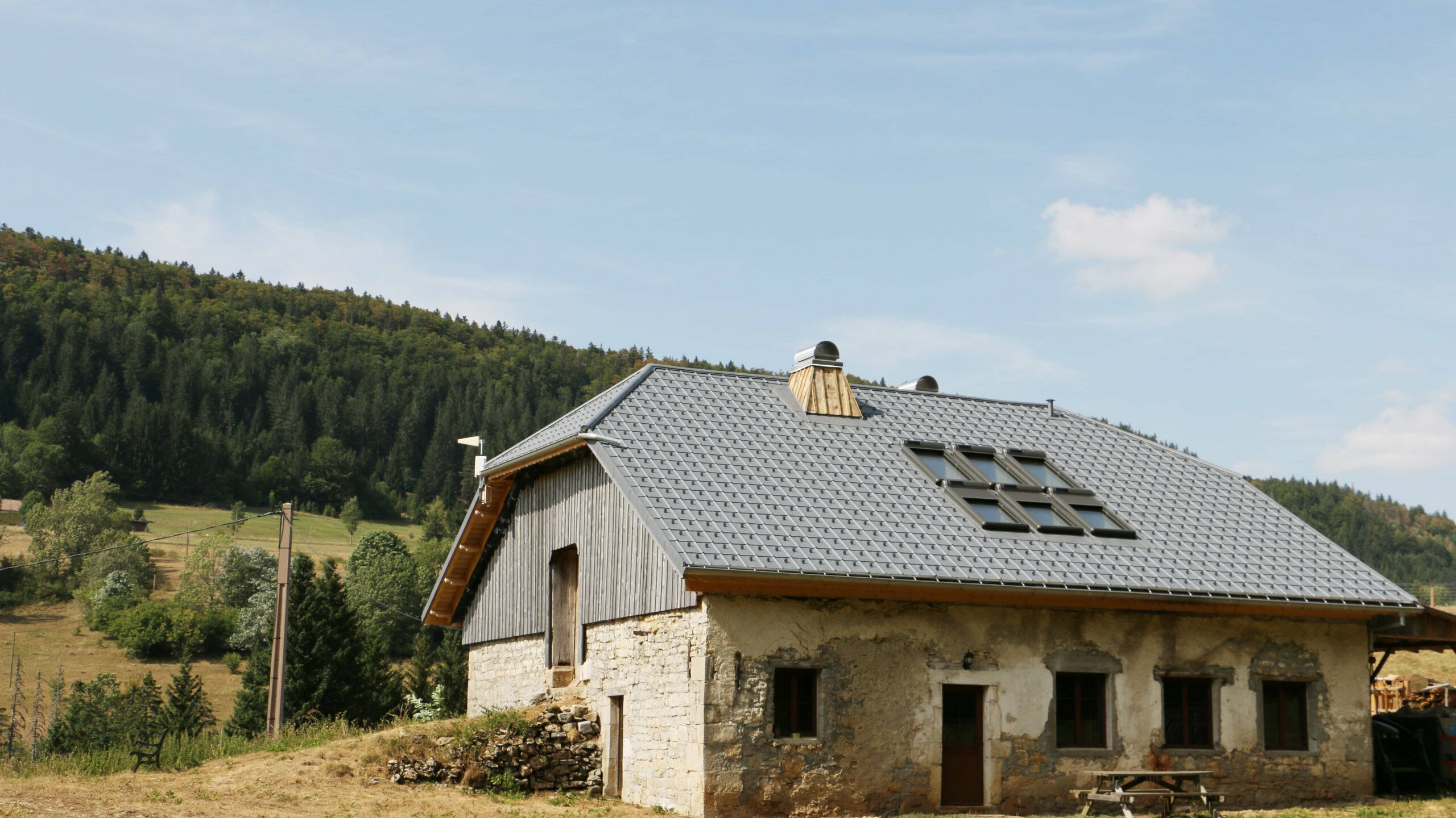 Vue d'ensemble de ce chalet dont la couverture a été rénovée avec les tuiles en aluminium prefa choisies dans la teinte P.10 gris pierre