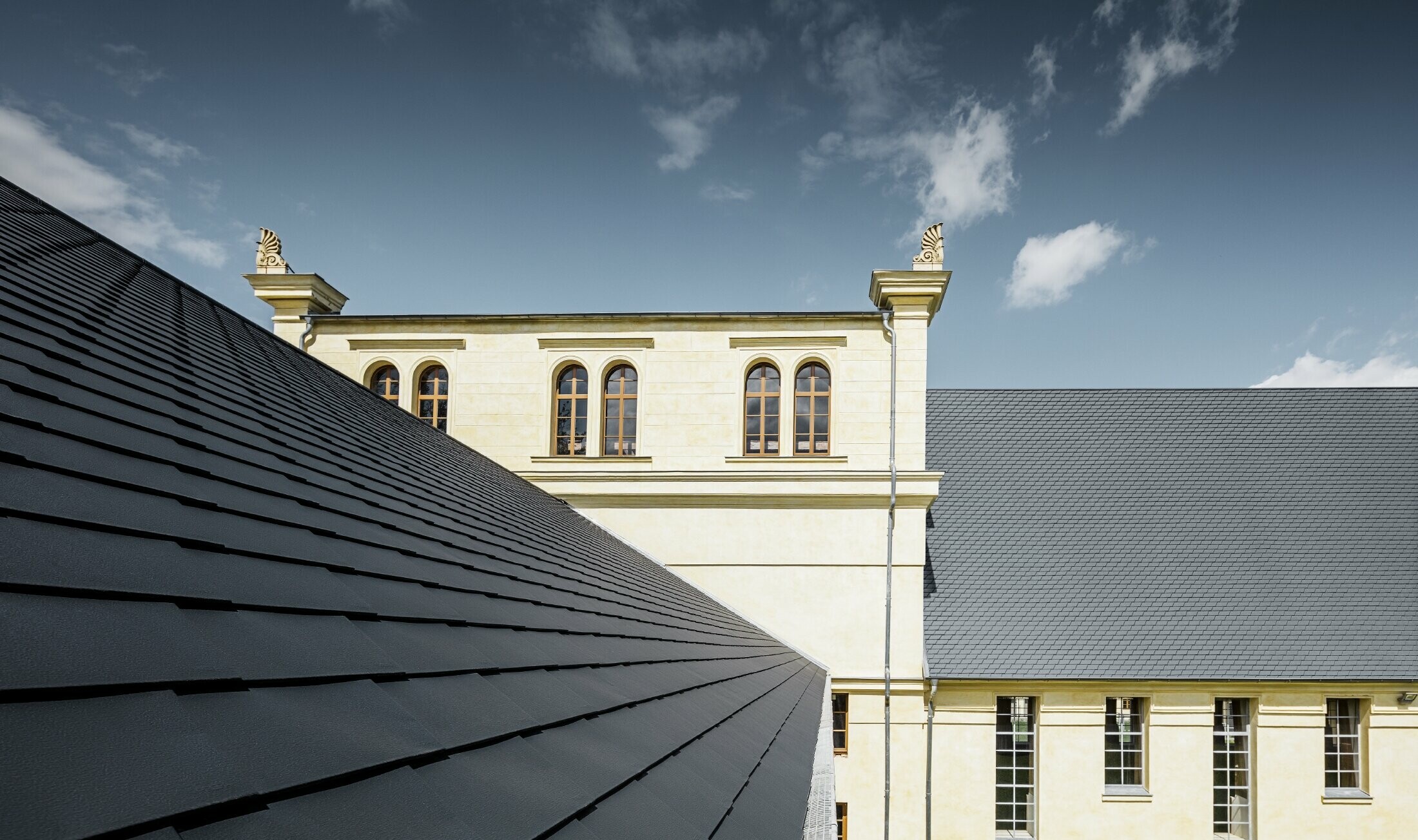 Vue détaillée du nouveau toit des écuries de Basedow ; le toit a été rénové à l'aide de bardeaux de toiture PREFA couleur anthracite.