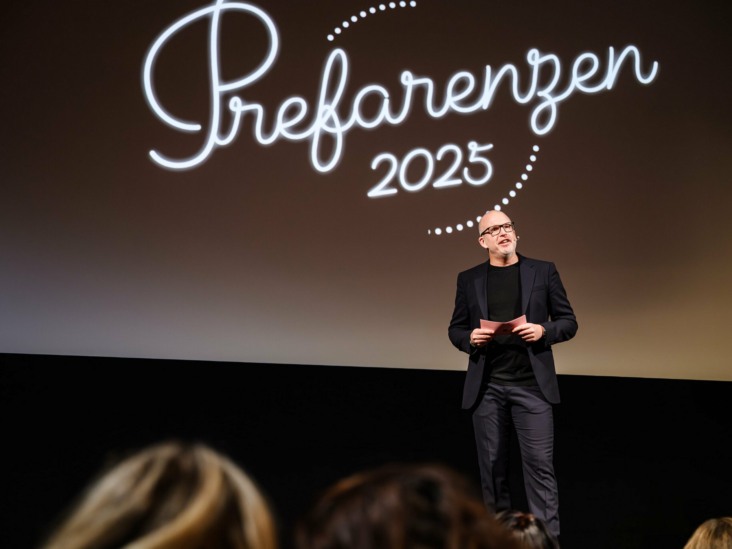 Jürgen Jungmair, directeur marketing de PREFA, prononce un discours lors de la première édition des PREFARENZEN 2025 au cinéma municipal de Vienne. À l’arrière-plan, le logo de l’événement « Prefarenzen 2025 » est visible.