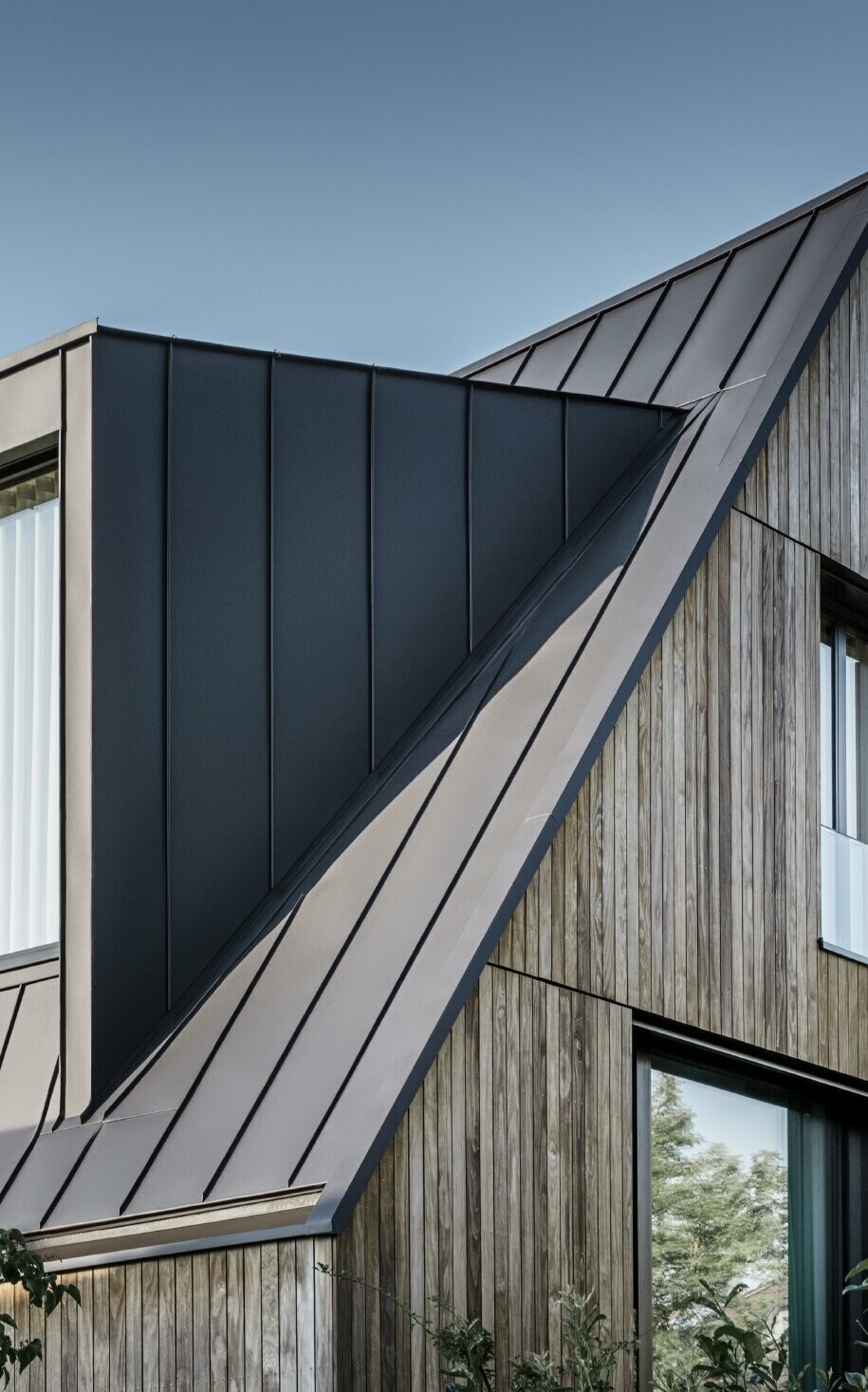 Toit à pignon raide avec lucarne, PREFALZ en P.10 anthracite Toit à pignon raide avec grande lucarne, recouvert avec PREFALZ de PREFA en anthracite et joints debout du toit combinés avec la façade en bois