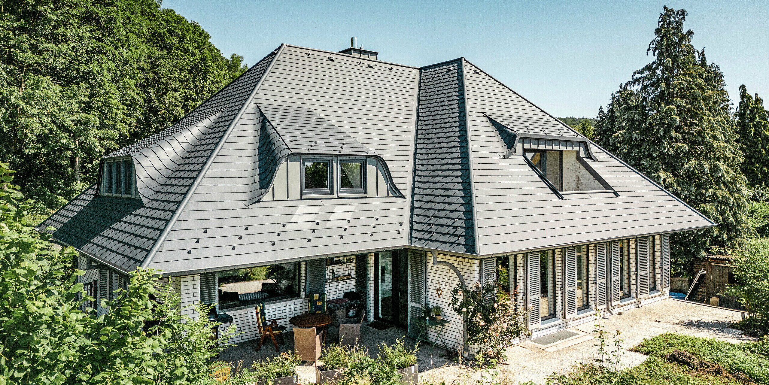 Toiture avec lucarnes cintrées d'une maison individuelle à Einbeck recouverte de bardeaux PREFA en anthracite P.10