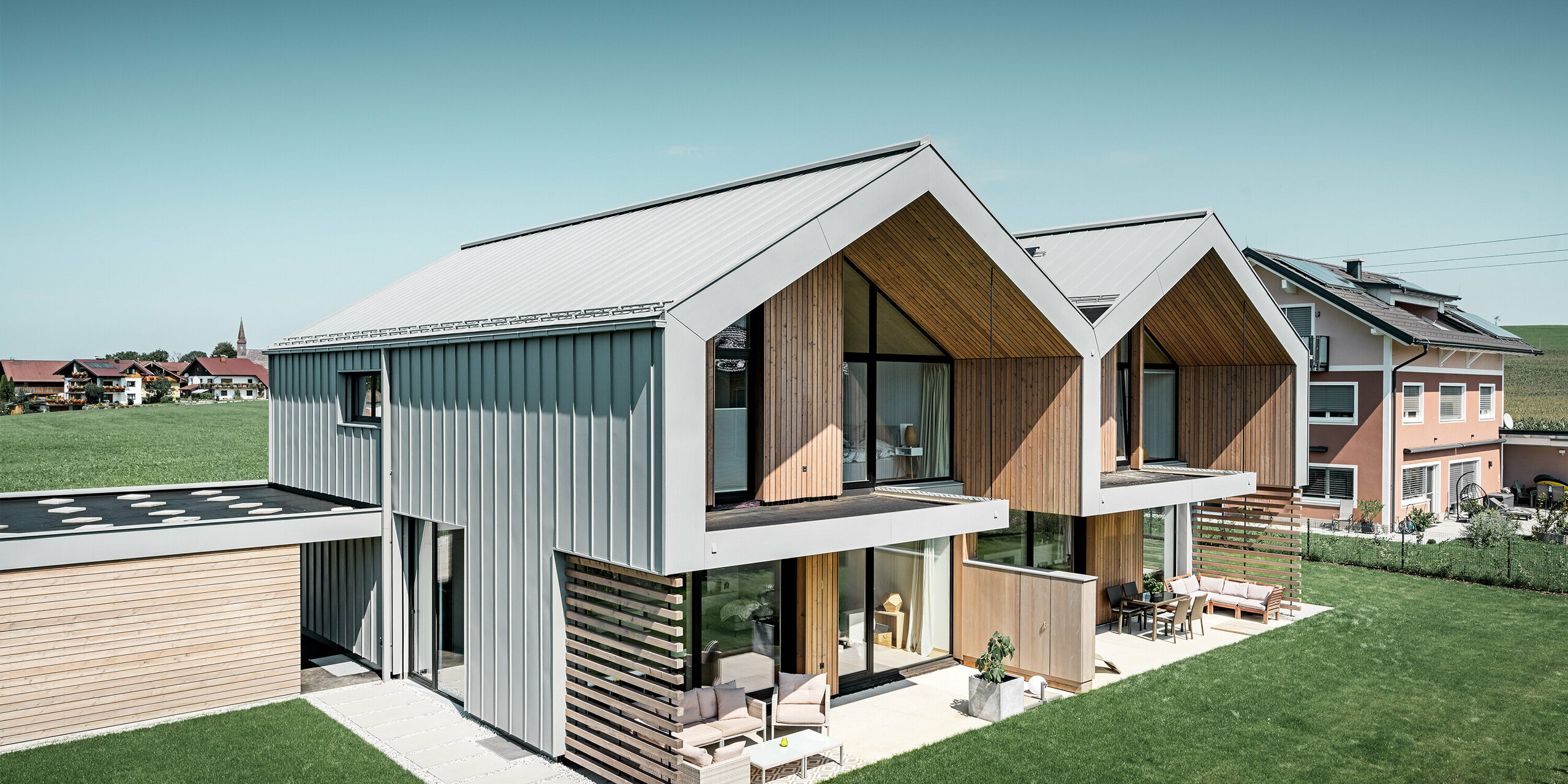 Maisons jumelées modernes avec enveloppe de bâtiment PREFALZ, le toit et la façade sont habillés de PREFALZ couleur gris quartz, tuyau de descente carré compris