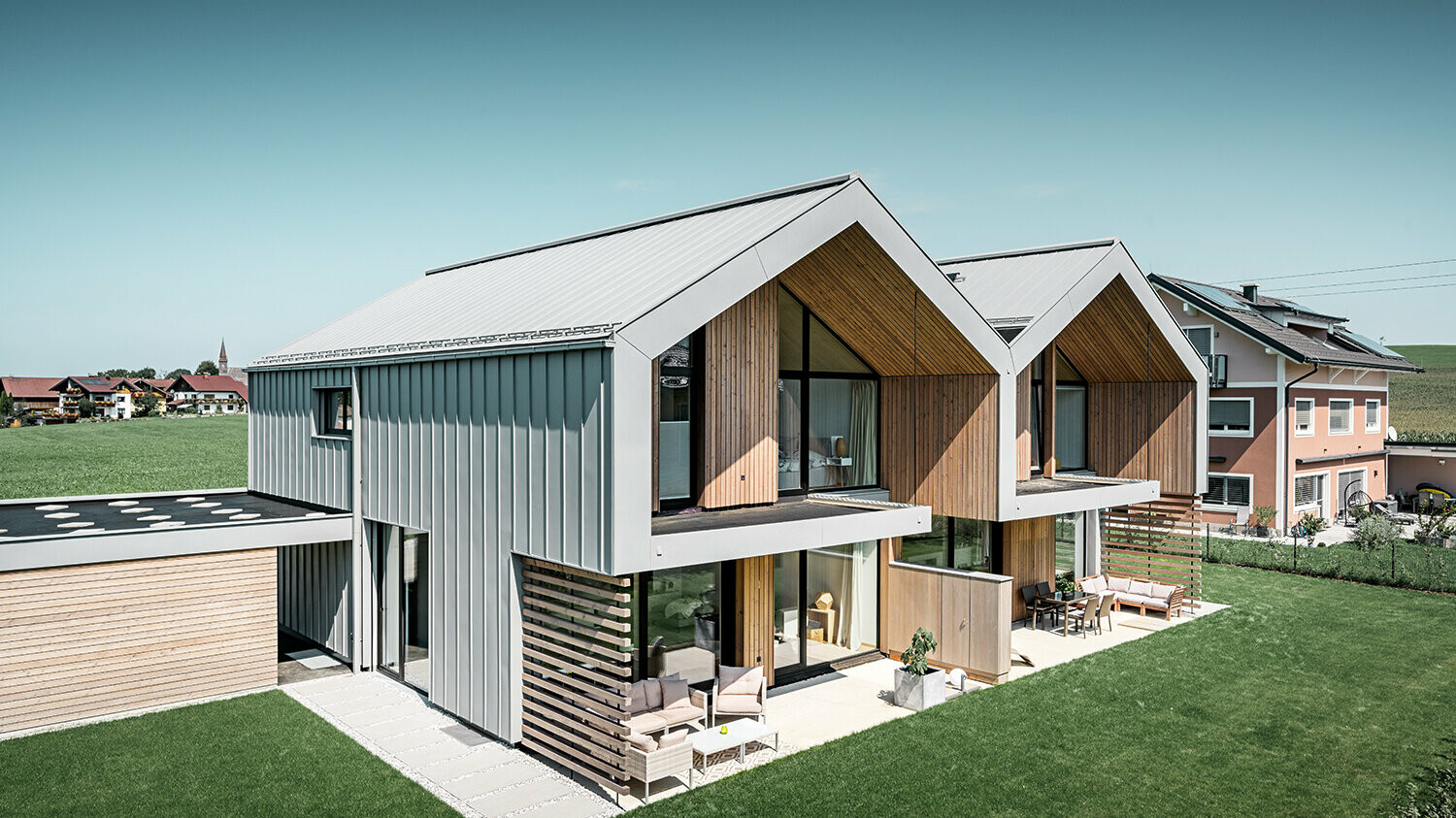 Maisons jumelées modernes avec enveloppe de bâtiment PREFALZ, le toit et la façade sont habillés de PREFALZ couleur gris quartz, tuyau de descente carré compris