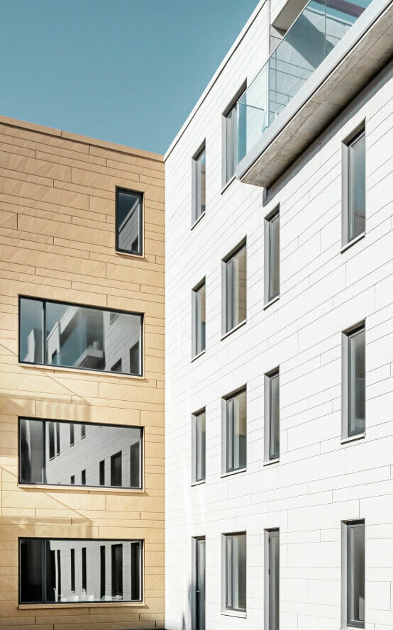Moderne Gebäude mit PREFA Siding.X Fassade in zwei Farben, die das innovative Fassadenmaterial und die moderne Architektur betonen.