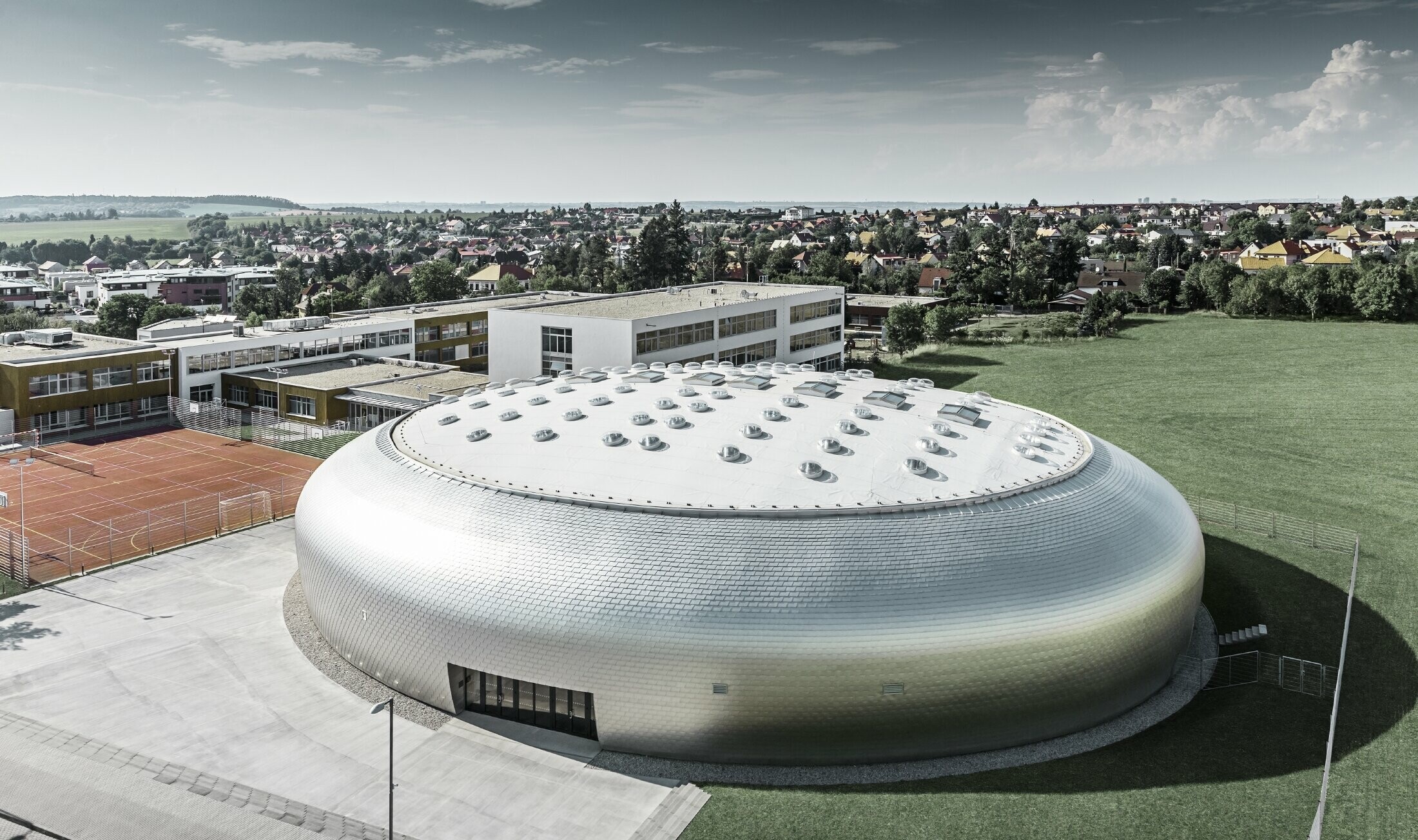 Vue aérienne du gymnase en République tchèque avec le losange de façade PREFA en alu brillant naturel.